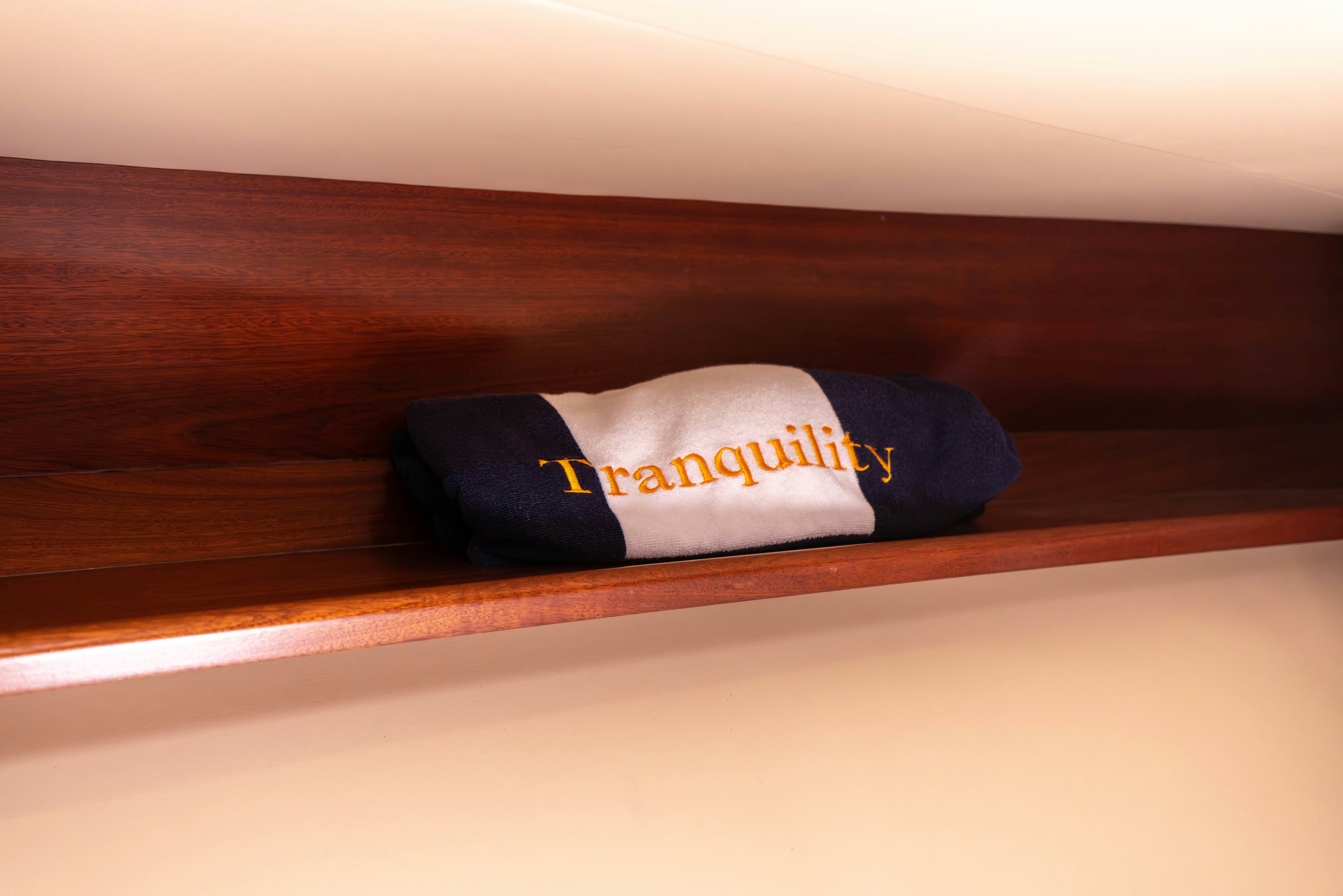 a blue and white cap on a wood surface aboard TRANQUILITY Yacht for Sale