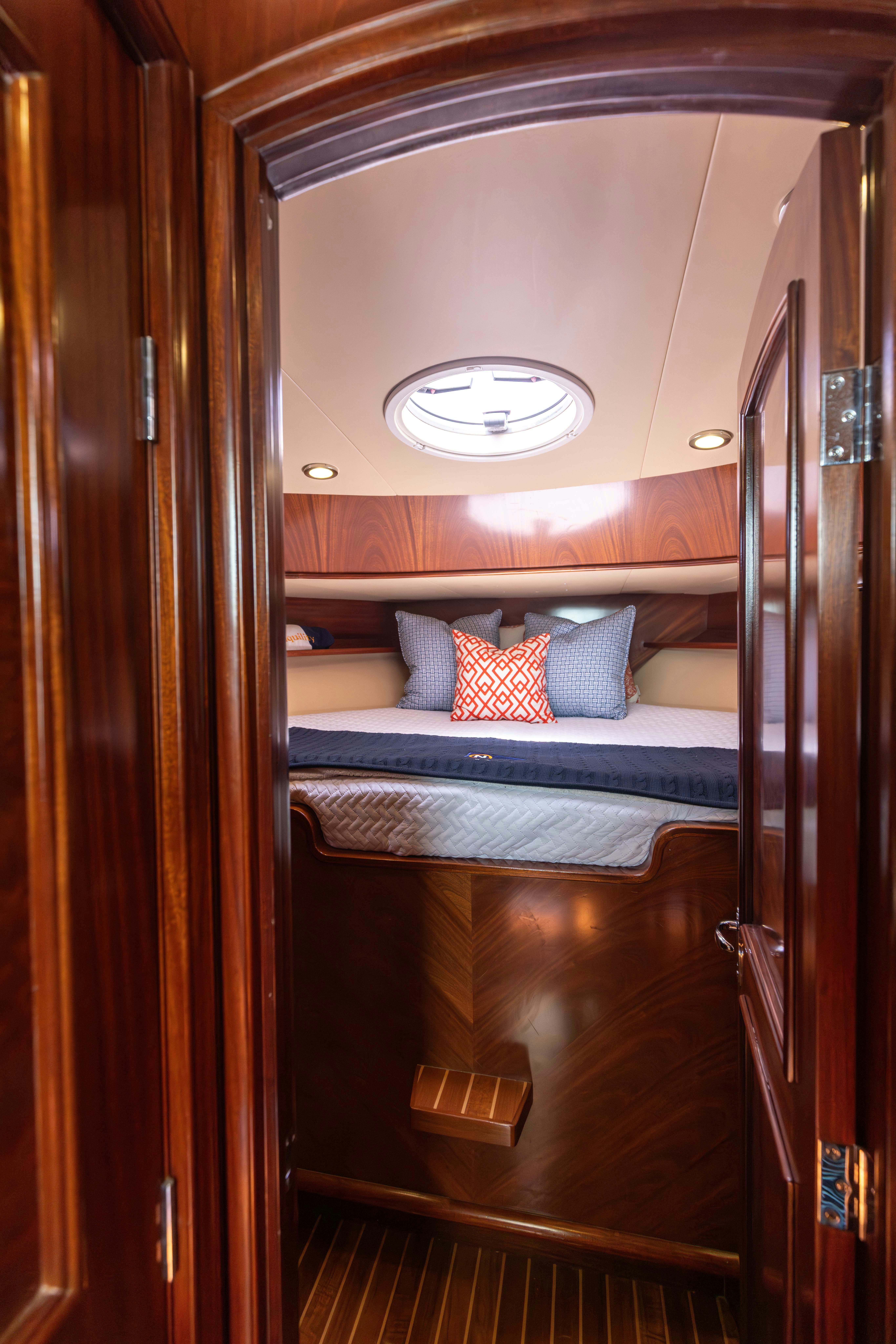 a bed with a blue and white bed and a mirror aboard TRANQUILITY Yacht for Sale