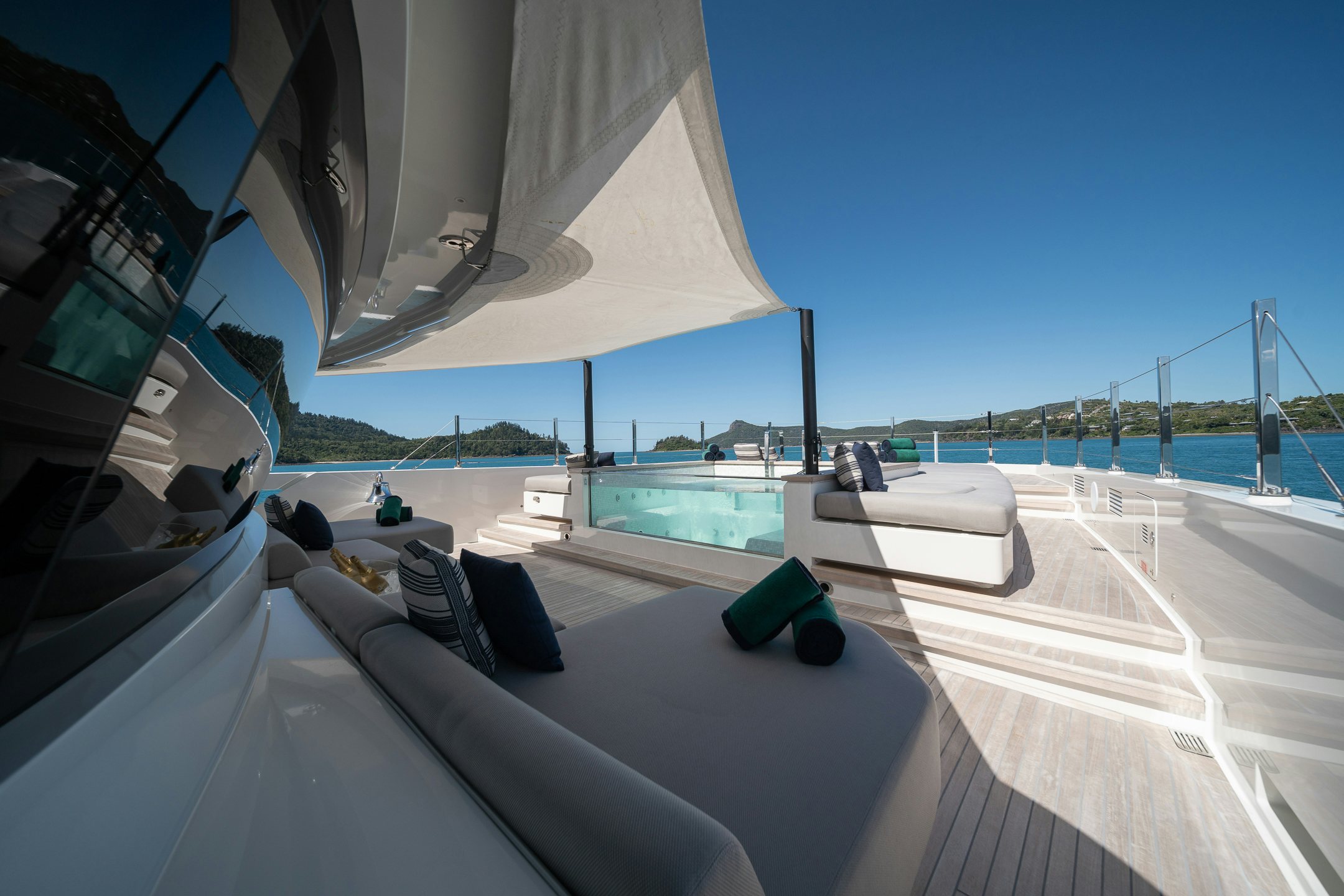 a pool with a deck and a deck and a building with a pool and blue sky aboard AIX Yacht for Charter