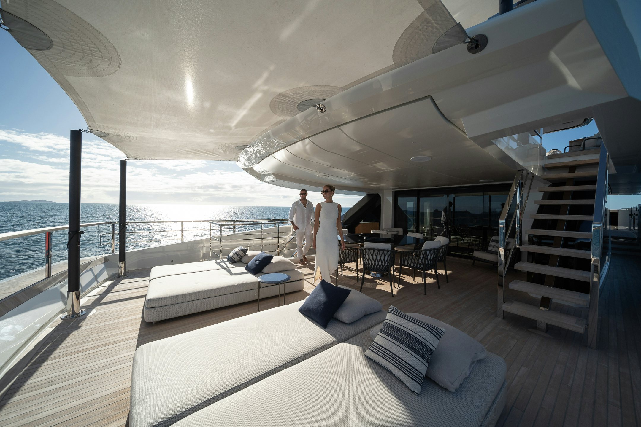 a couple of men standing on a deck over looking the ocean aboard AIX Yacht for Charter
