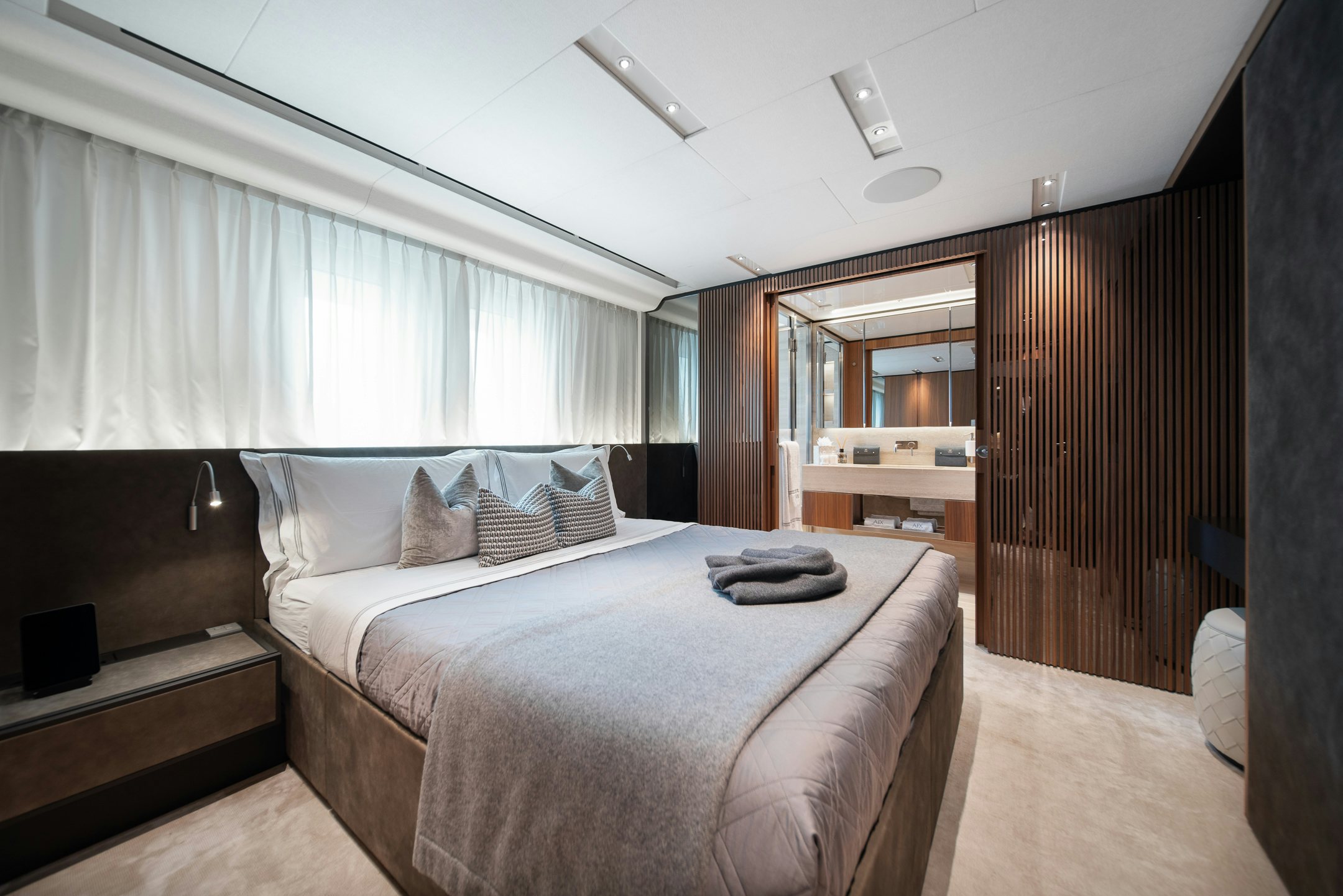 a bedroom with a bed and a wood door aboard AIX Yacht for Charter