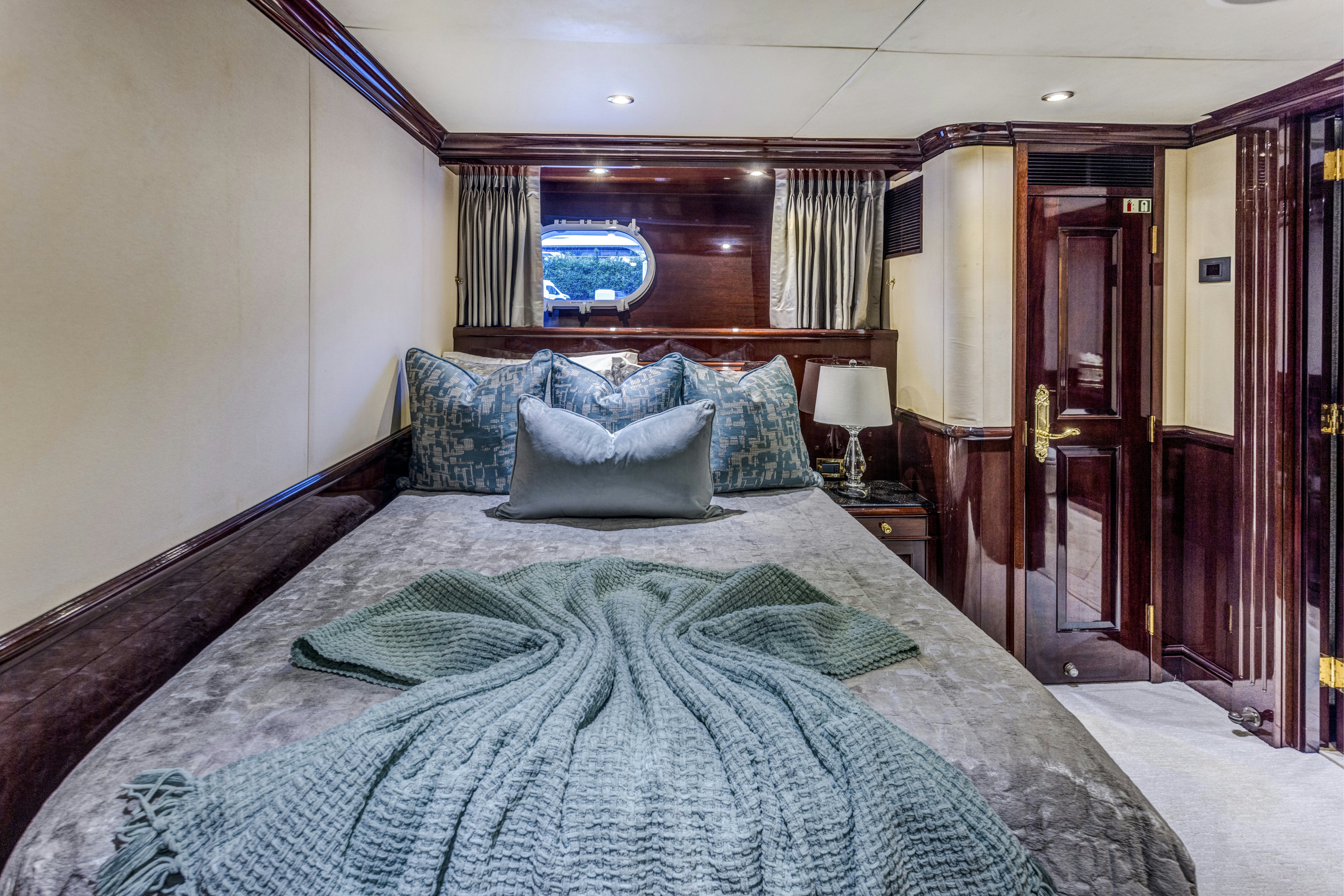 a bed with a blue comforter aboard IONIAN PRINCESS Yacht for Sale