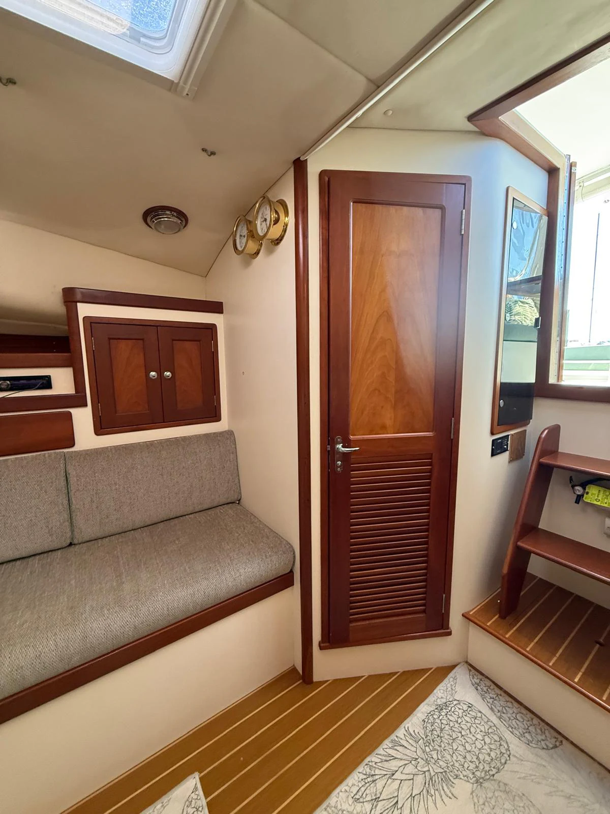 a living room with a couch and a wood door aboard LARK Yacht for Sale