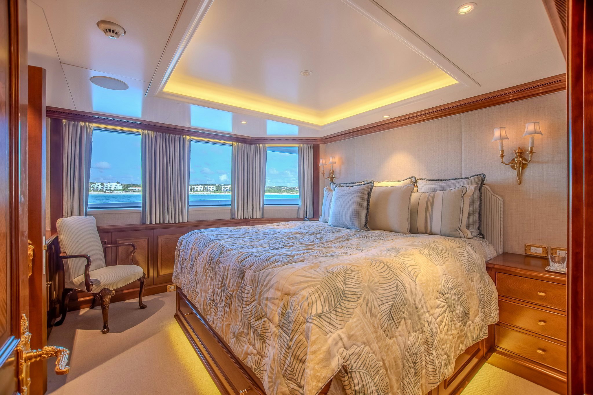 a bed with a large window aboard LADY KATHRYN V Yacht for Charter