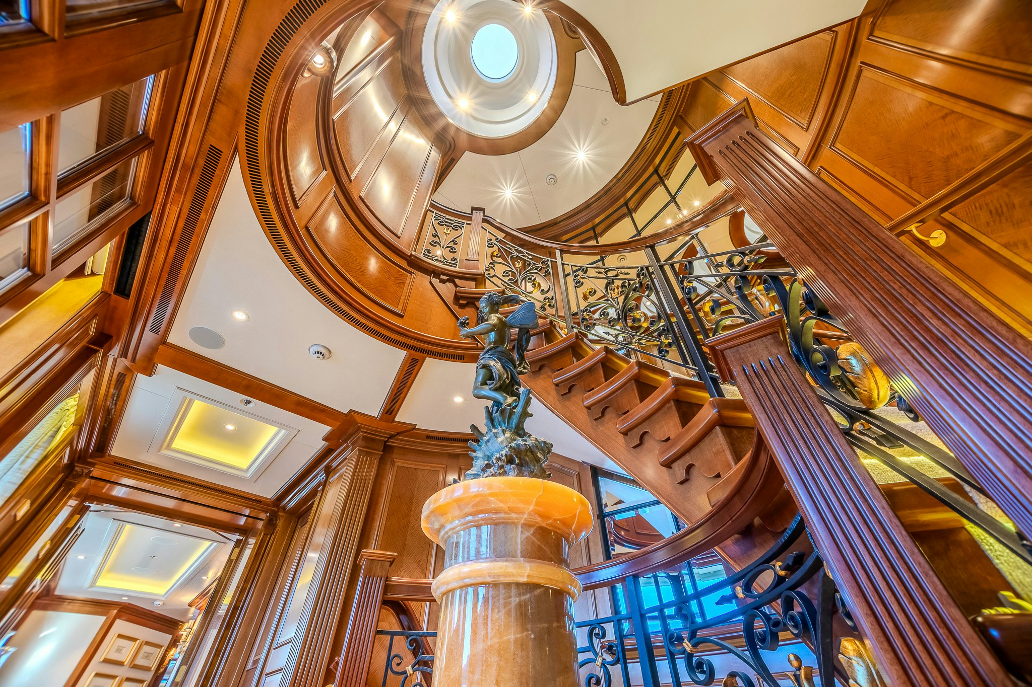 a large staircase with a chandelier aboard LADY KATHRYN V Yacht for Charter