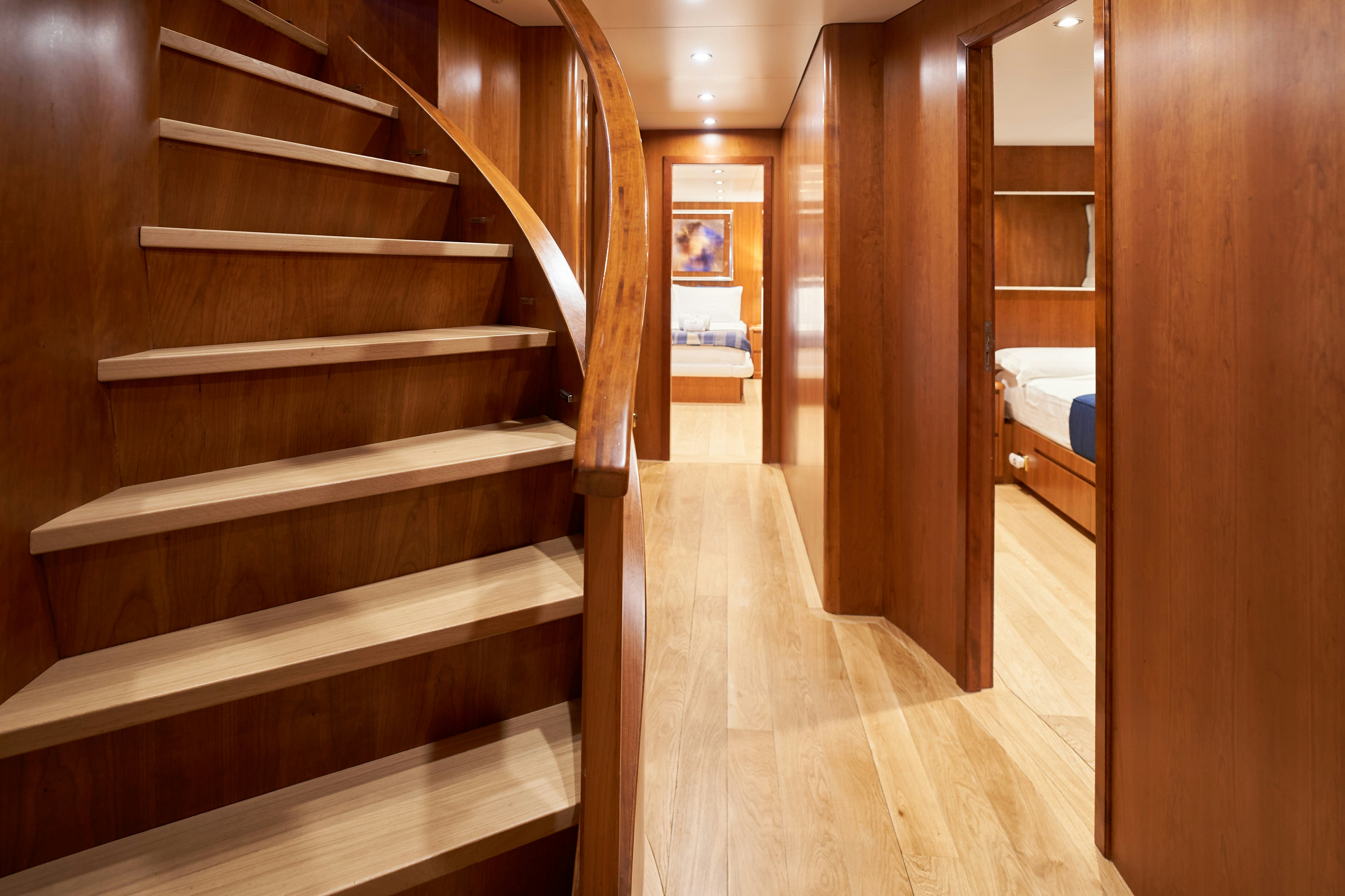 a room with wooden stairs aboard L'INSTANT IV Yacht for Sale