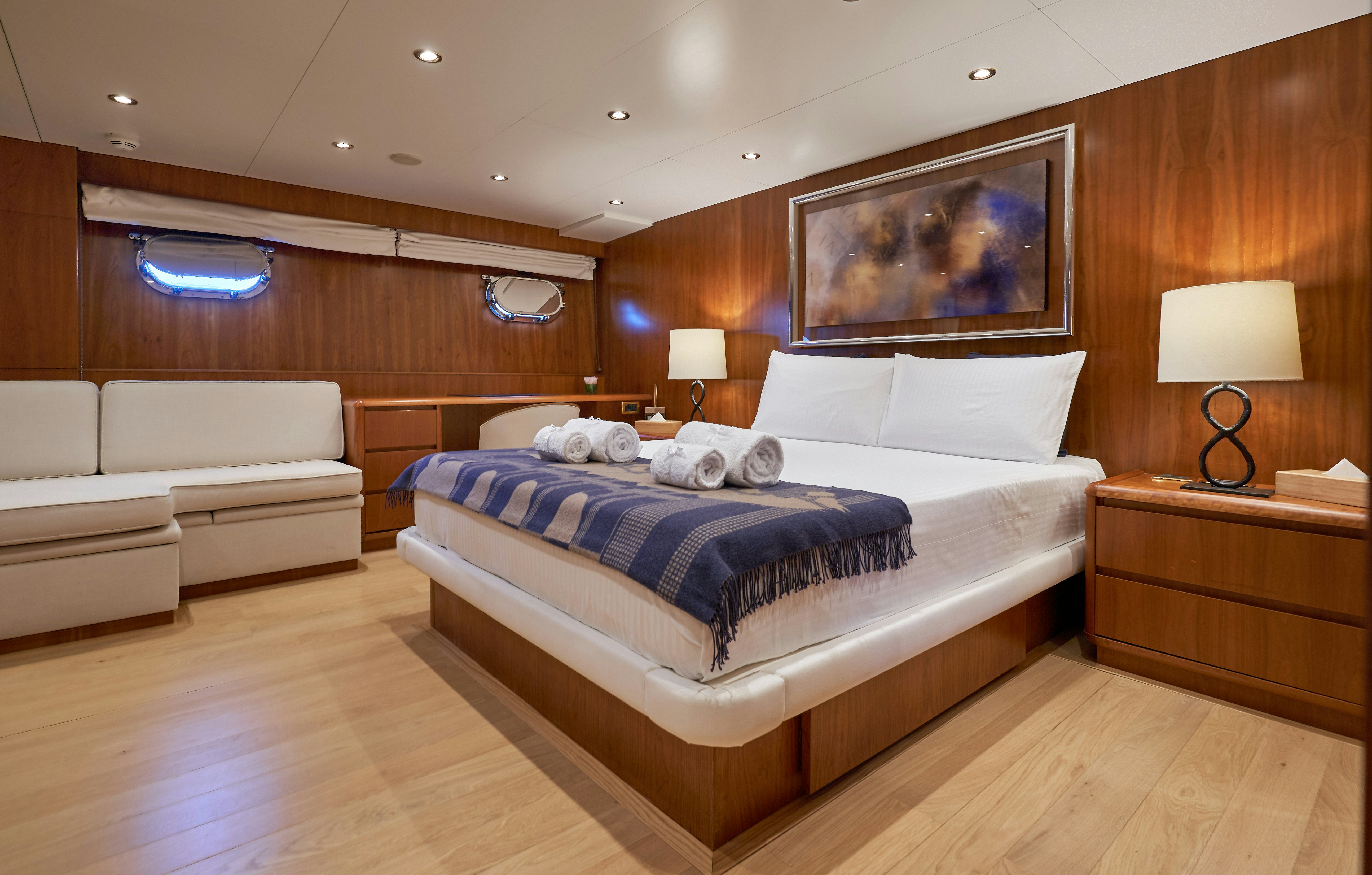 a room with a bed and a couch aboard L'INSTANT IV Yacht for Sale