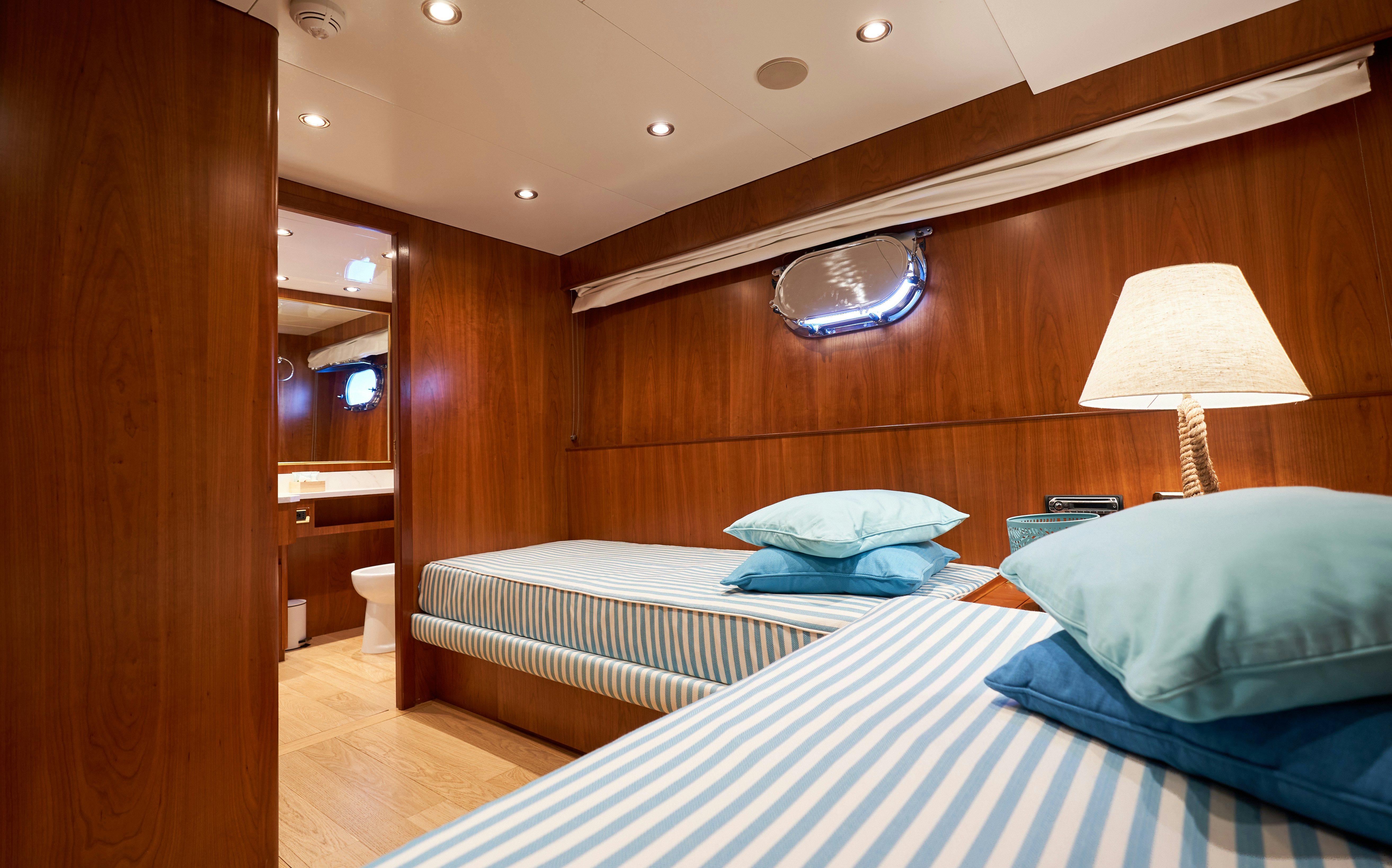 a room with a bed and a wood wall aboard L'INSTANT IV Yacht for Sale