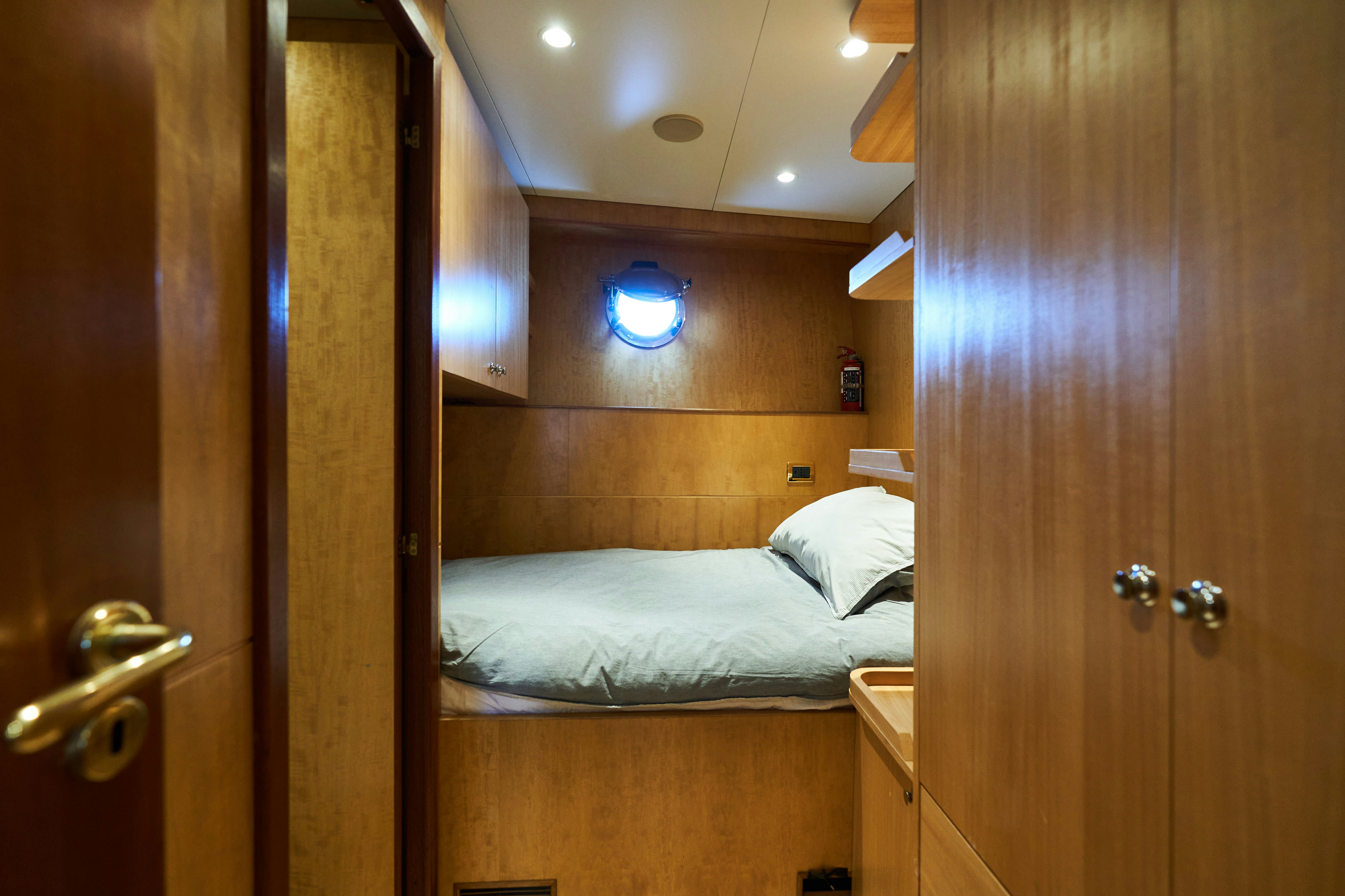 a room with a bed and a wood door aboard L'INSTANT IV Yacht for Sale