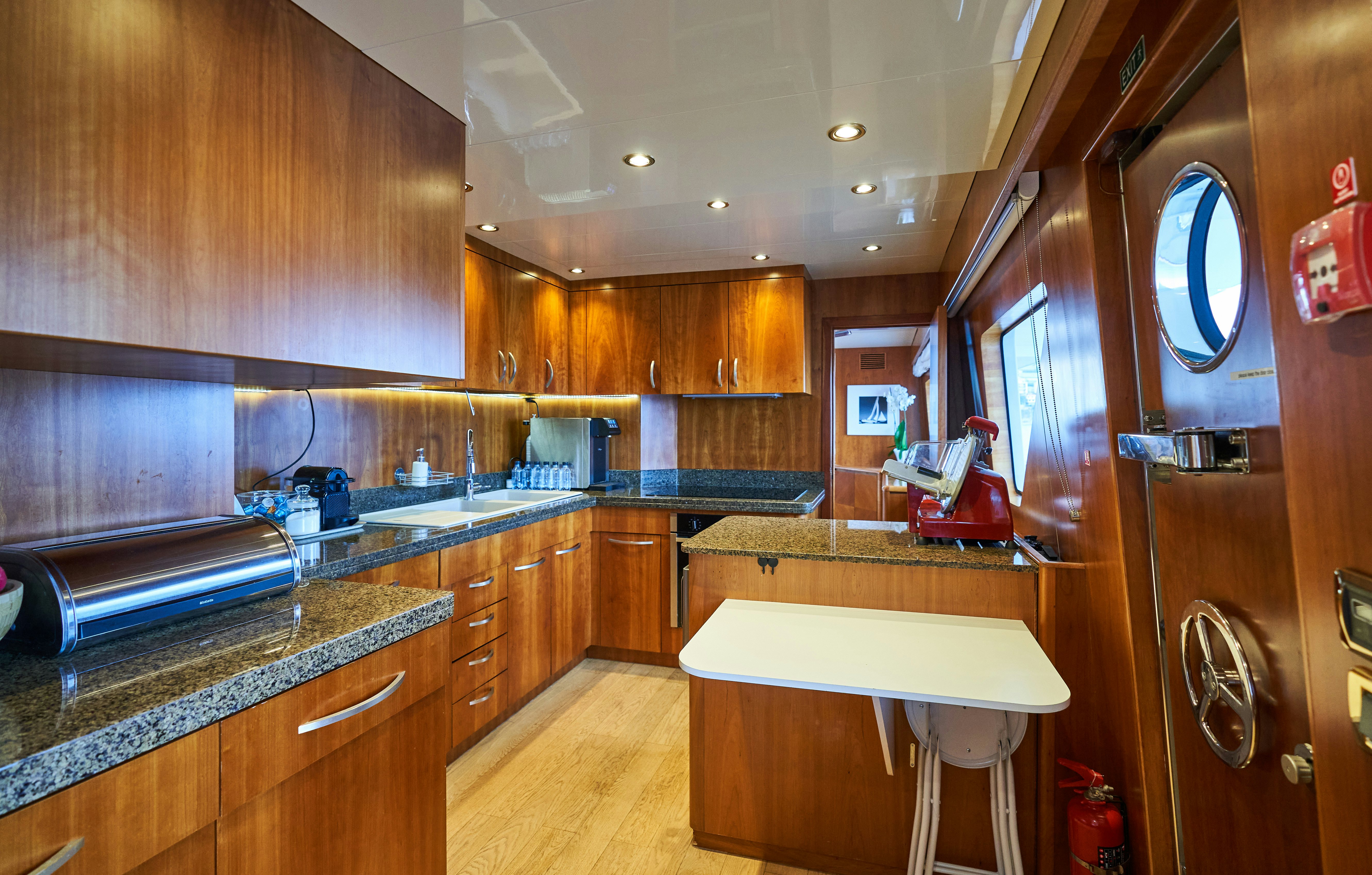 a kitchen with wooden cabinets aboard L'INSTANT IV Yacht for Sale