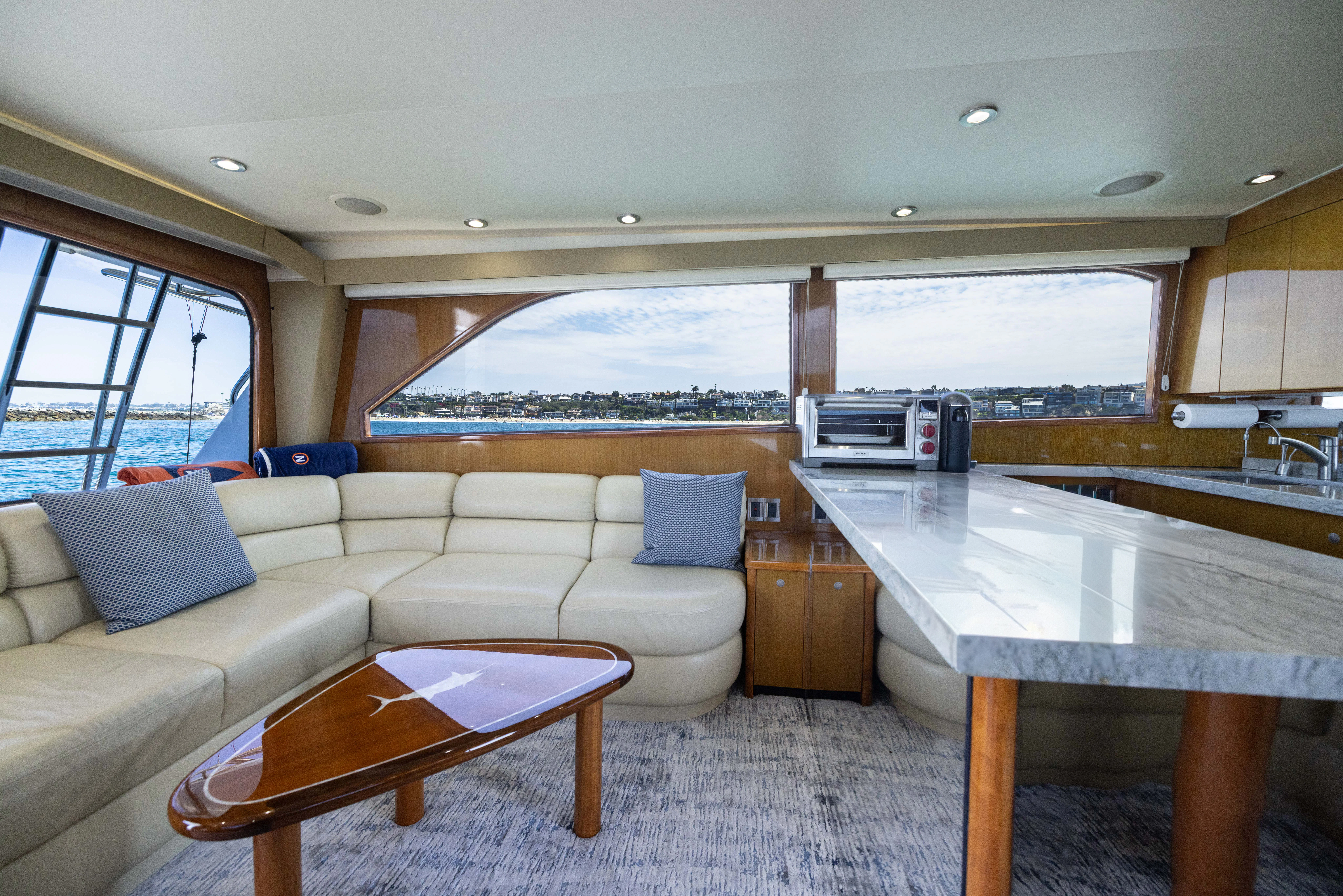 a living room with a large white table and a large window aboard ANEJO Yacht for Sale