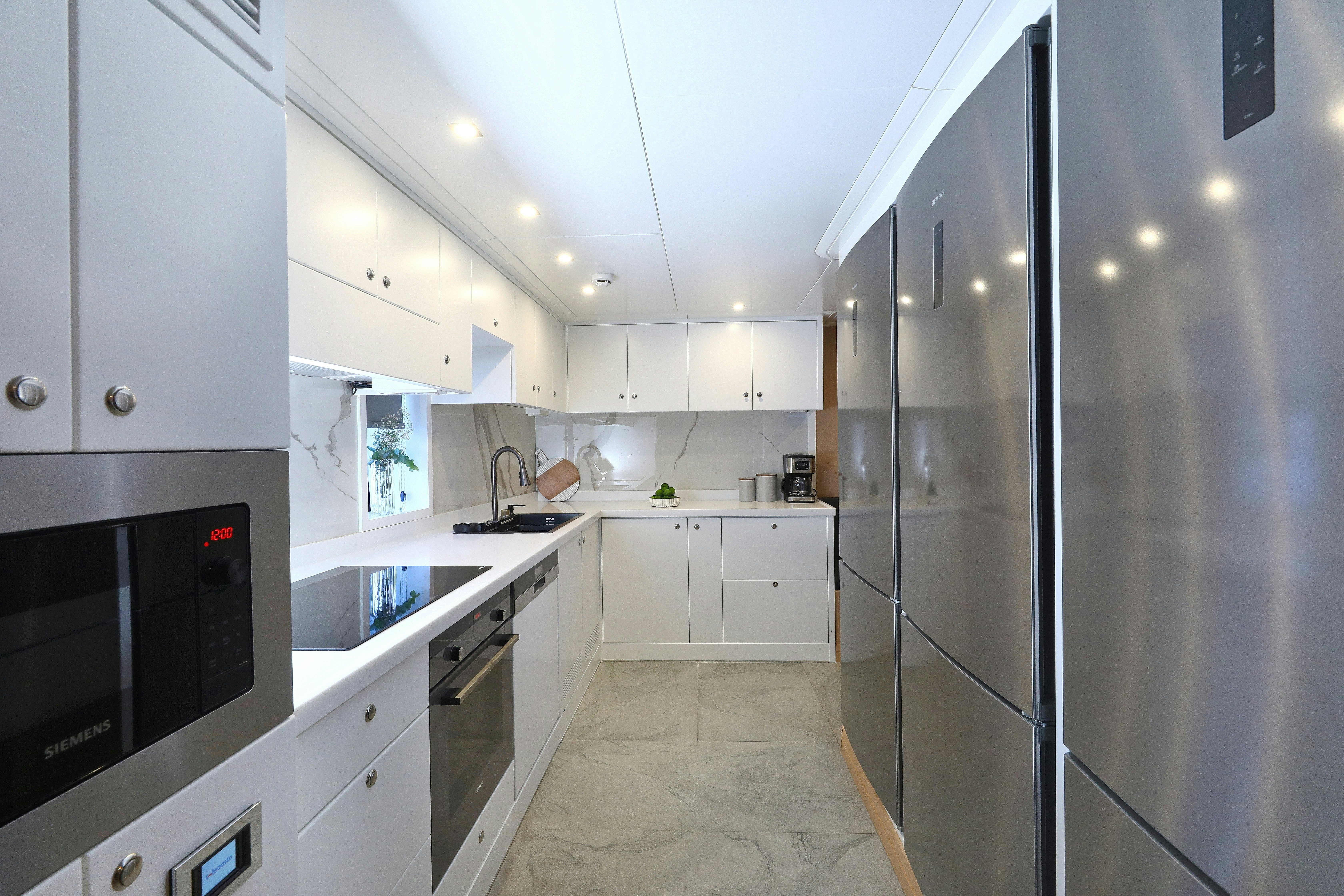 a kitchen with white cabinets aboard AEGEAN EXPLORER 26M HULL #3 Yacht for Sale