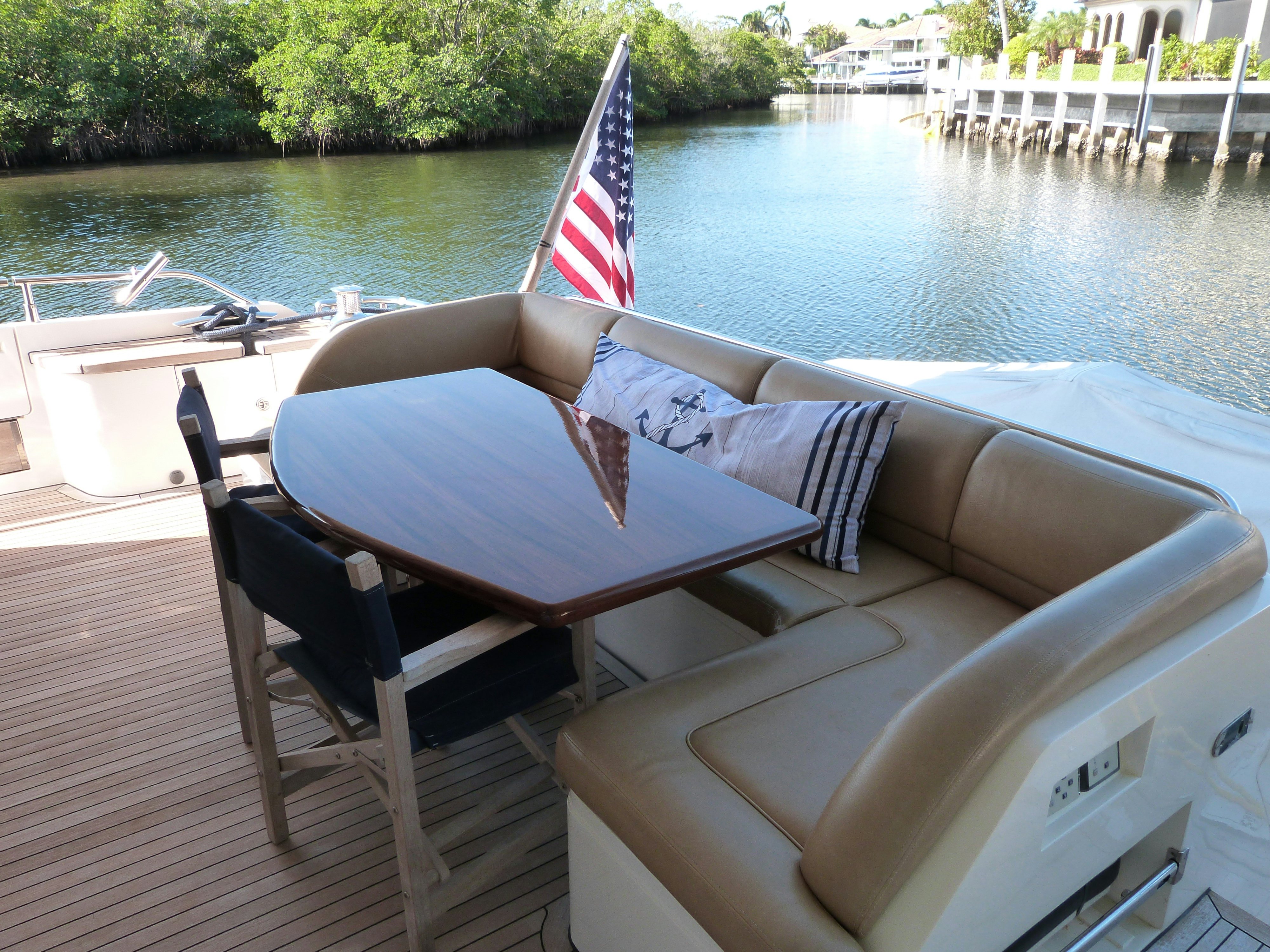 a person lying on a lounge chair on a dock with a flag on the back aboard LADY A Yacht for Sale