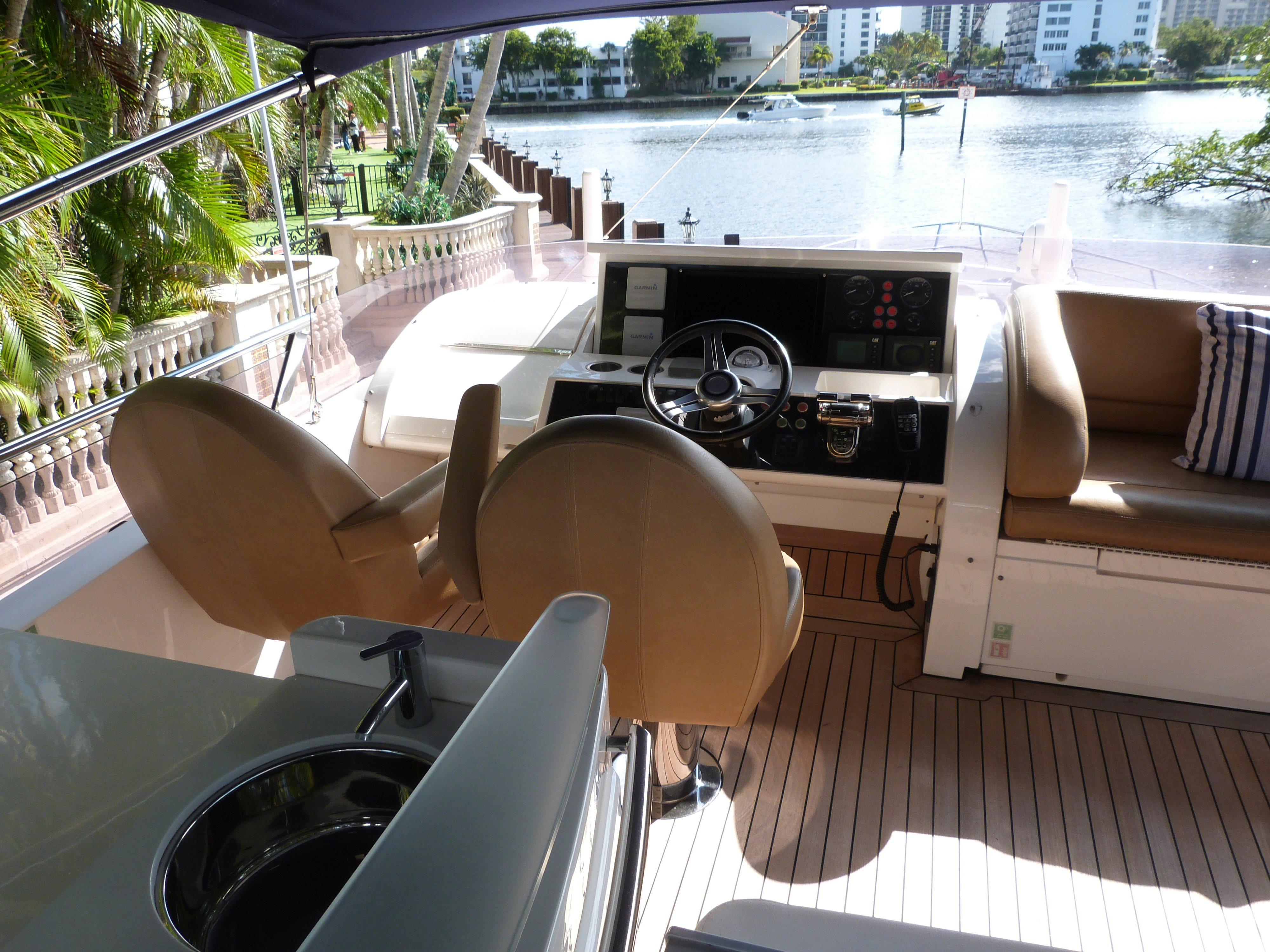 a table and chairs on a balcony overlooking a body of water aboard LADY A Yacht for Sale