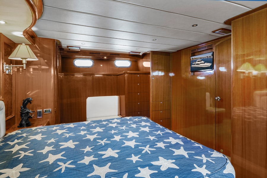 a bed with blue sheets and a blue sheet aboard PORK CHOP Yacht for Sale