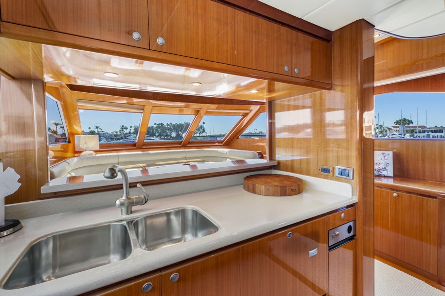 a kitchen with wooden cabinets aboard PORK CHOP Yacht for Sale