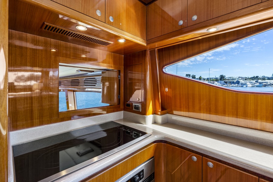 a kitchen with wooden cabinets aboard PORK CHOP Yacht for Sale