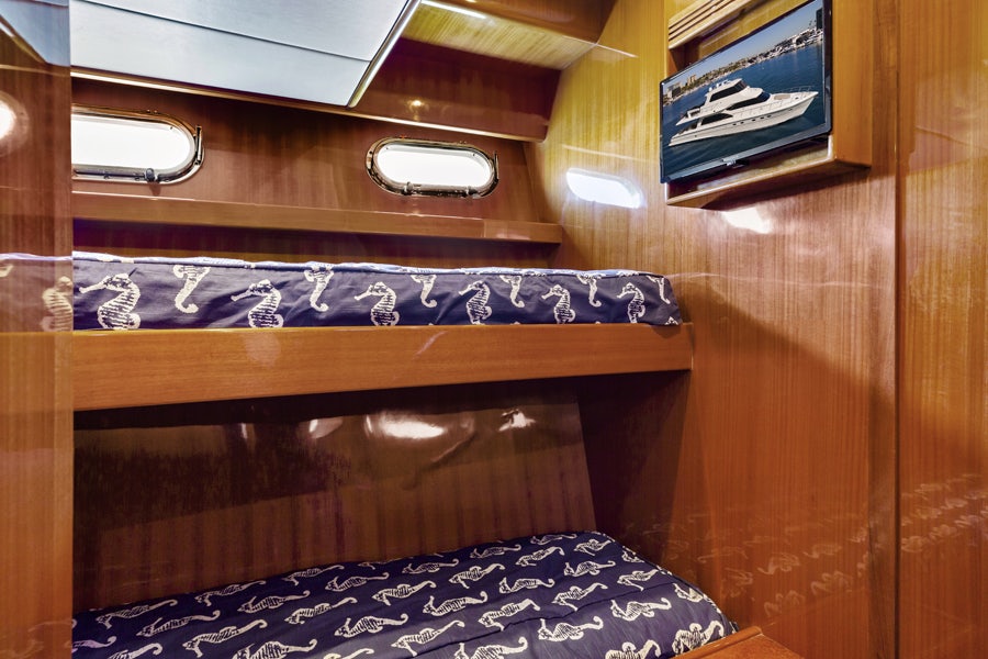 a wood shelf with a blue and white pillow on it aboard PORK CHOP Yacht for Sale