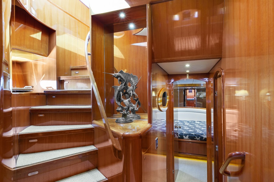 a wooden staircase with a statue aboard PORK CHOP Yacht for Sale