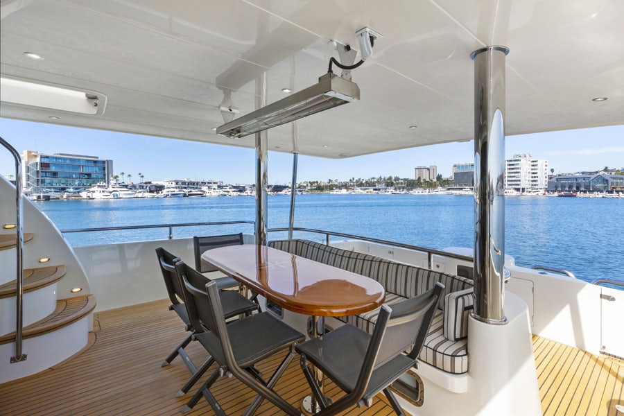 a table and chairs on a deck overlooking a body of water aboard PORK CHOP Yacht for Sale