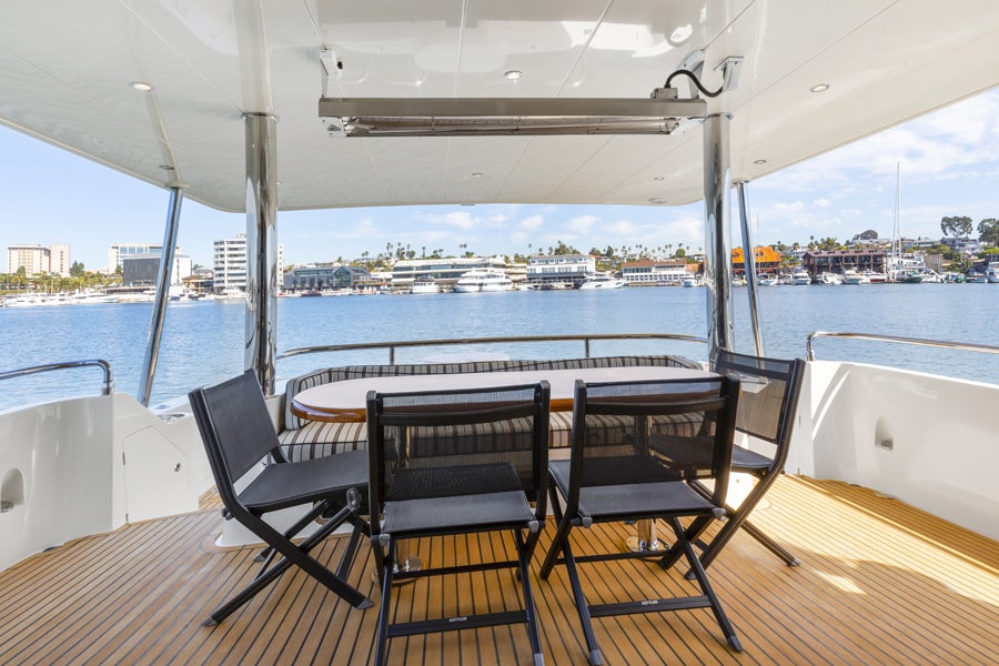 a table and chairs on a deck overlooking a body of water aboard PORK CHOP Yacht for Sale