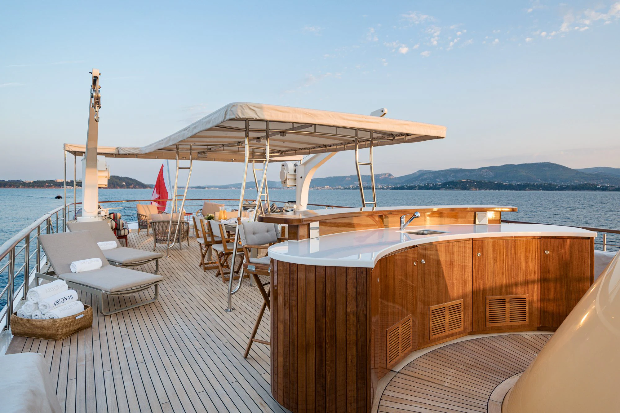 a deck with chairs and tables on it by the water aboard ARIONAS Yacht for Charter