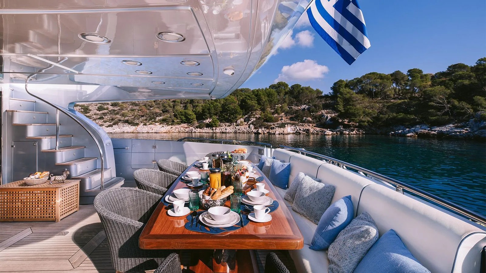 a table with food on it next to a large body of water aboard ELVI Yacht for Charter