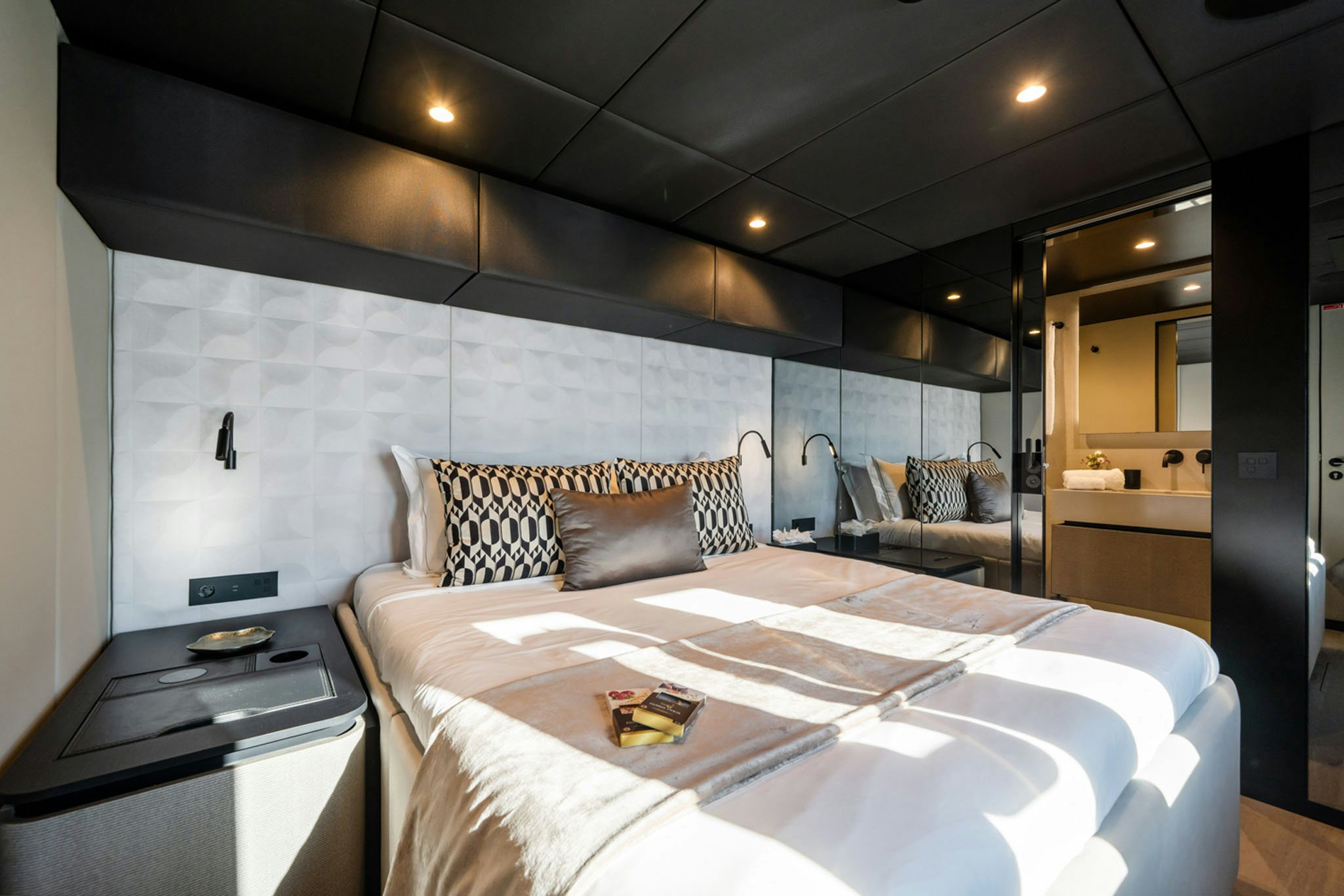 a bed with a white bed spread aboard GRAYA Yacht for Charter