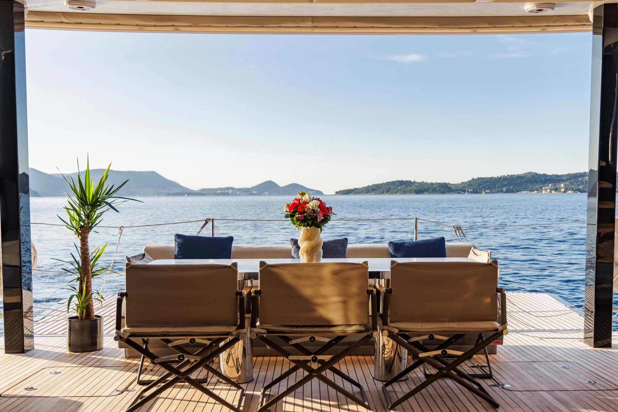 a table and chairs on a patio overlooking a body of water aboard GRAYA Yacht for Charter