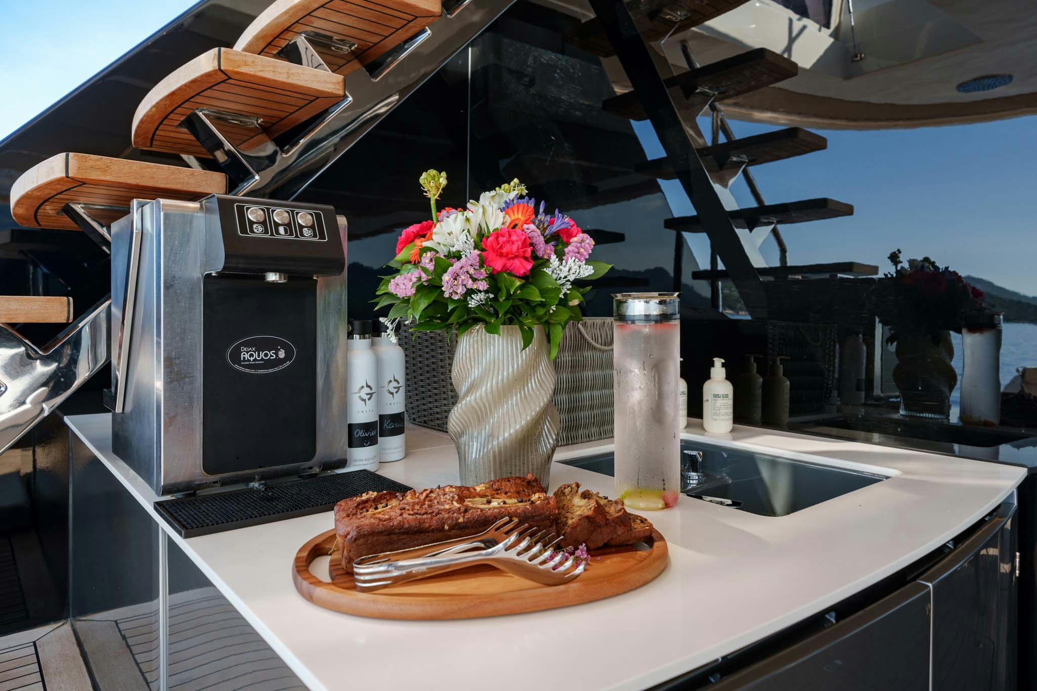 a kitchen counter with a flower vase and a bottle of perfume aboard GRAYA Yacht for Charter