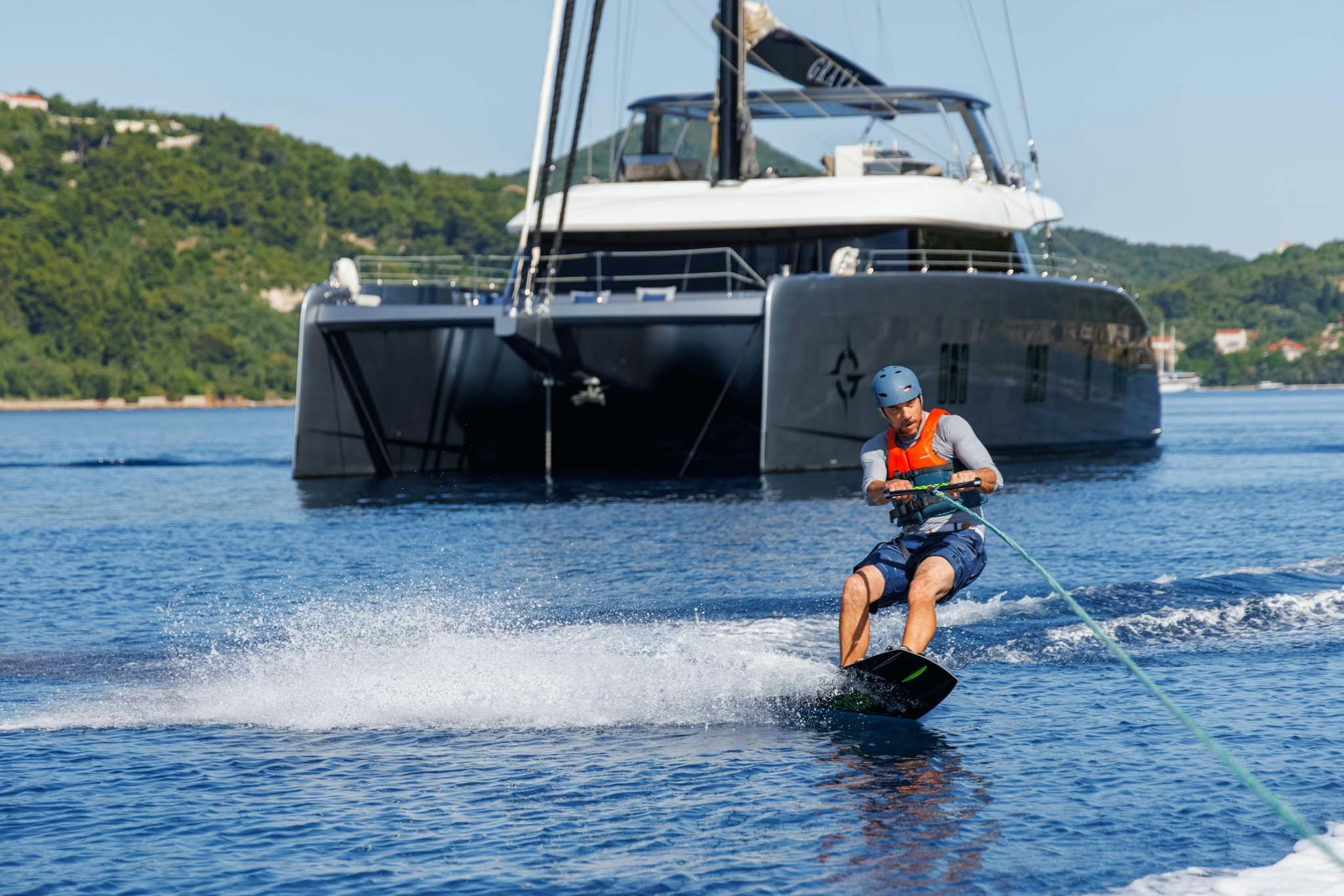 a man water skiing in front of a boat aboard GRAYA Yacht for Charter