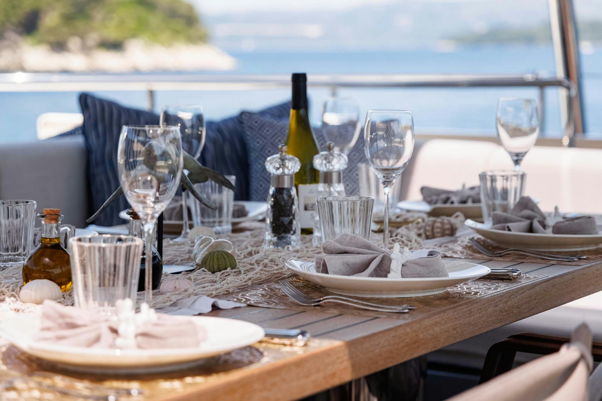 a table with food and wine bottles aboard GRAYA Yacht for Charter