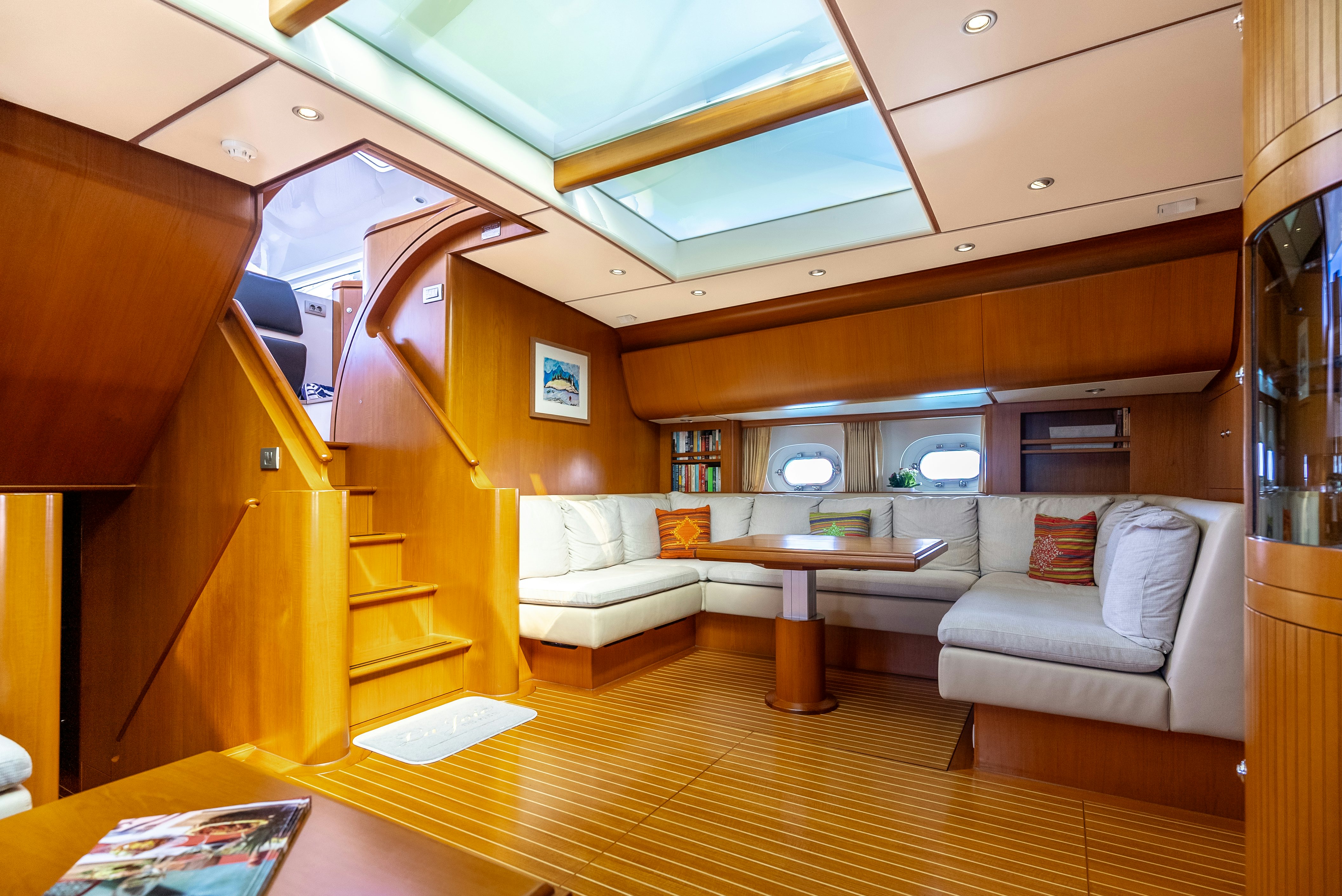 a living room with a wood staircase aboard LA JOIE DE MER Yacht for Sale