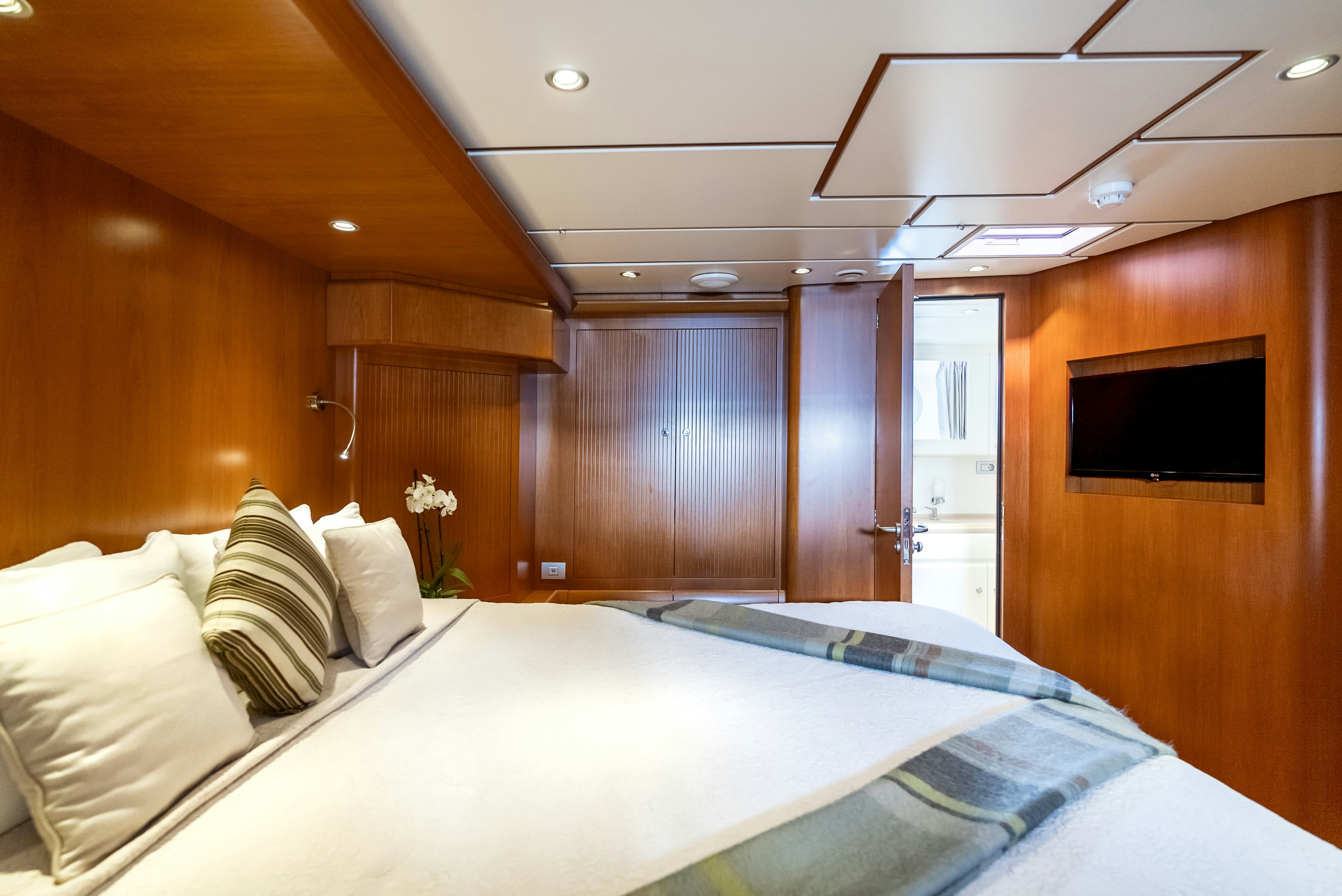 a room with a bed and a television aboard LA JOIE DE MER Yacht for Sale