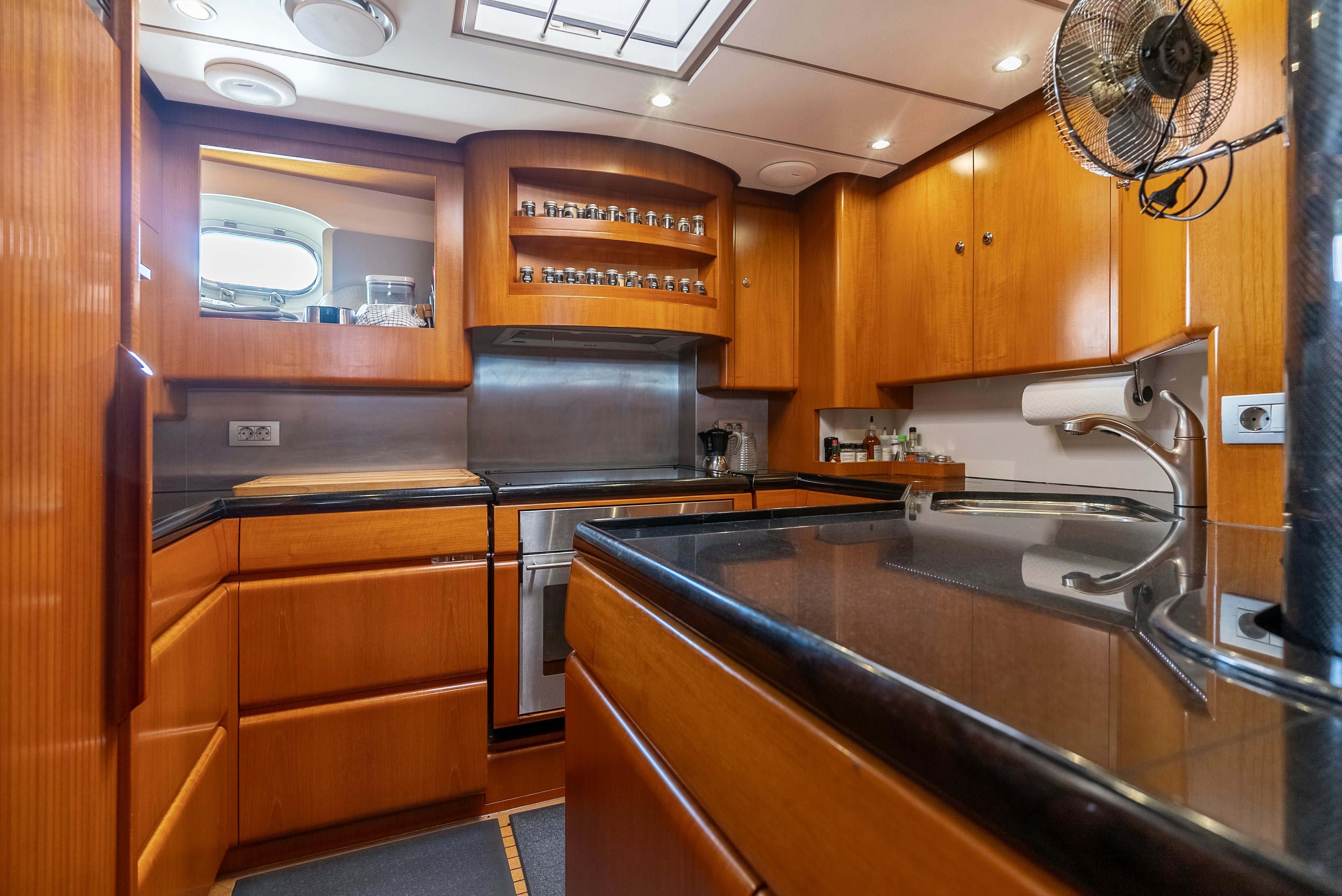 a kitchen with wooden cabinets aboard LA JOIE DE MER Yacht for Sale