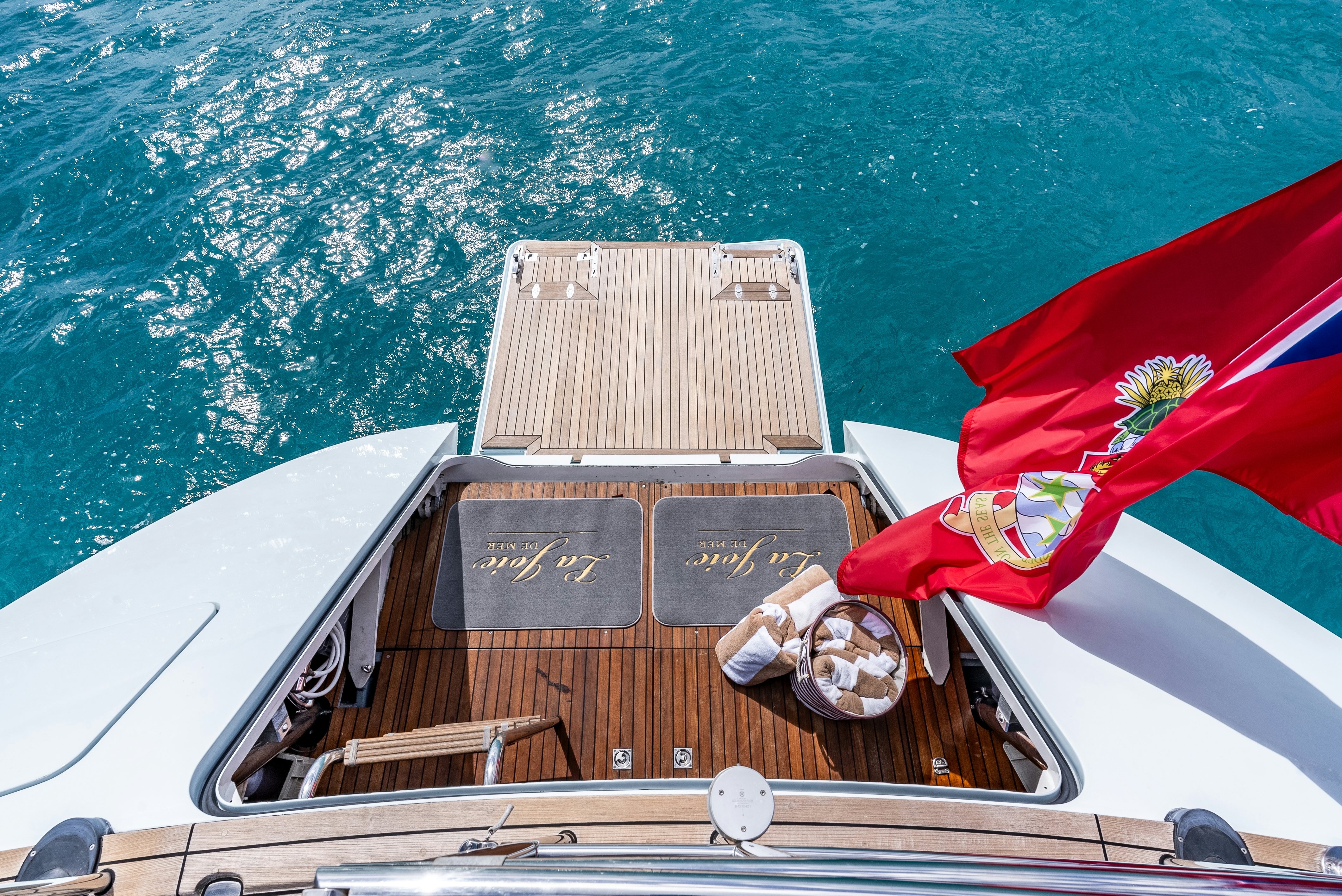 a boat with a red and white flag on it aboard LA JOIE DE MER Yacht for Sale