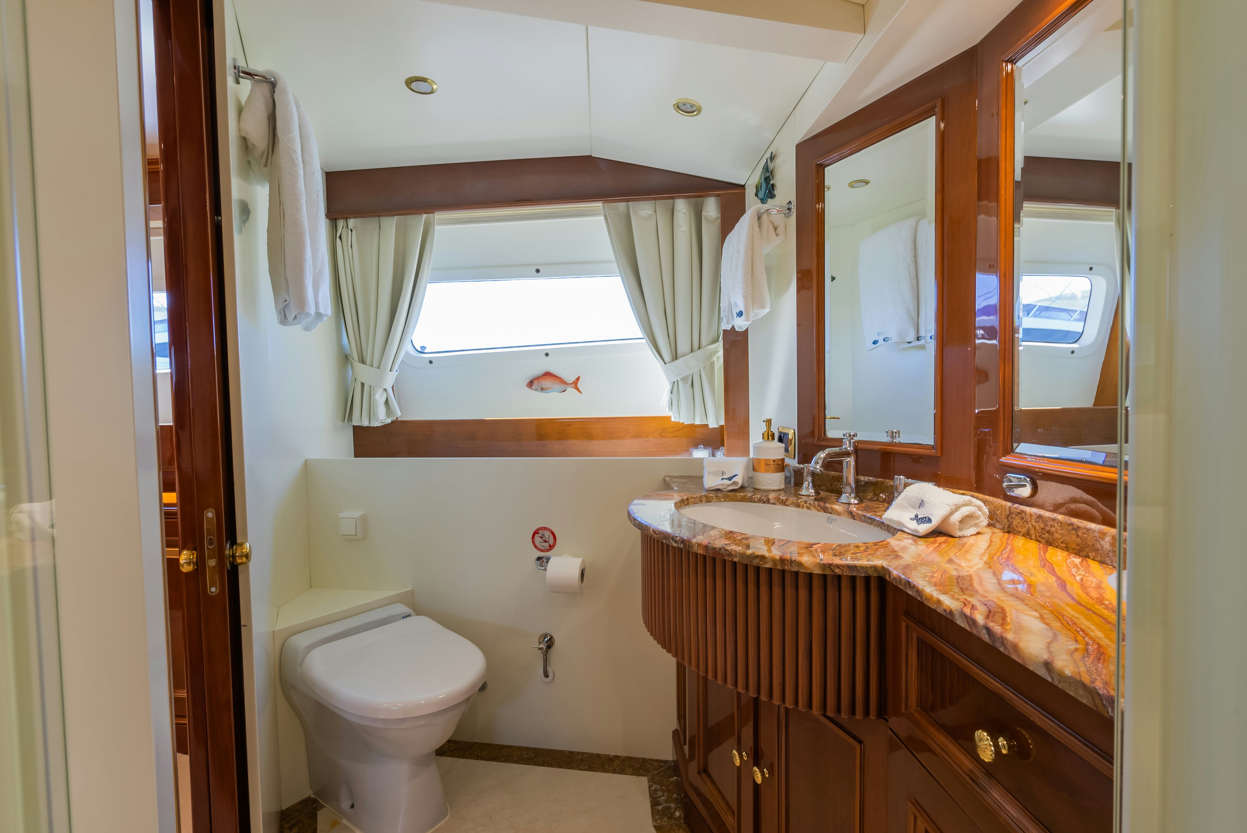 a bathroom with a sink toilet and a mirror aboard STELLA FIERA Yacht for Sale