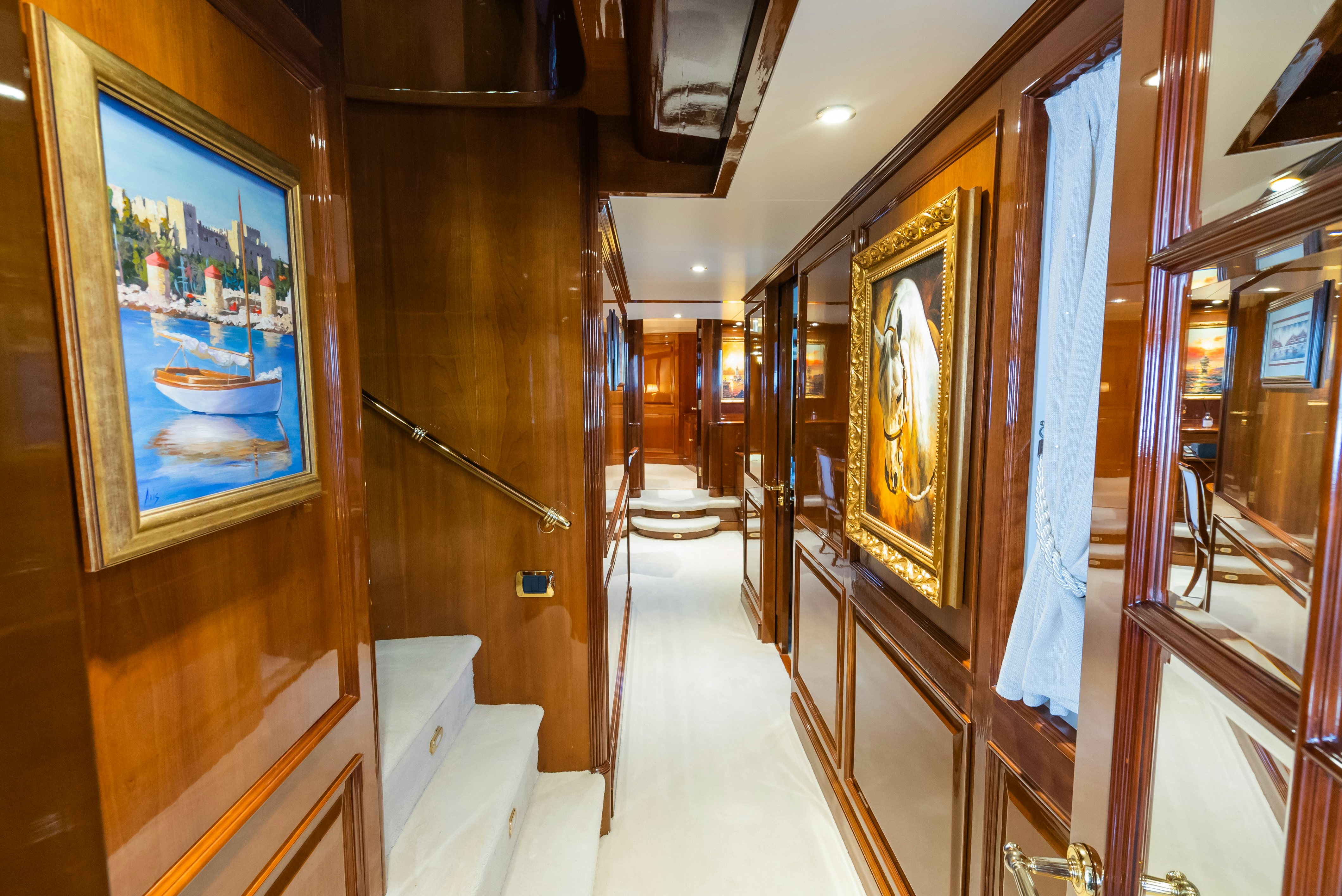 a hallway with paintings on the wall aboard STELLA FIERA Yacht for Sale