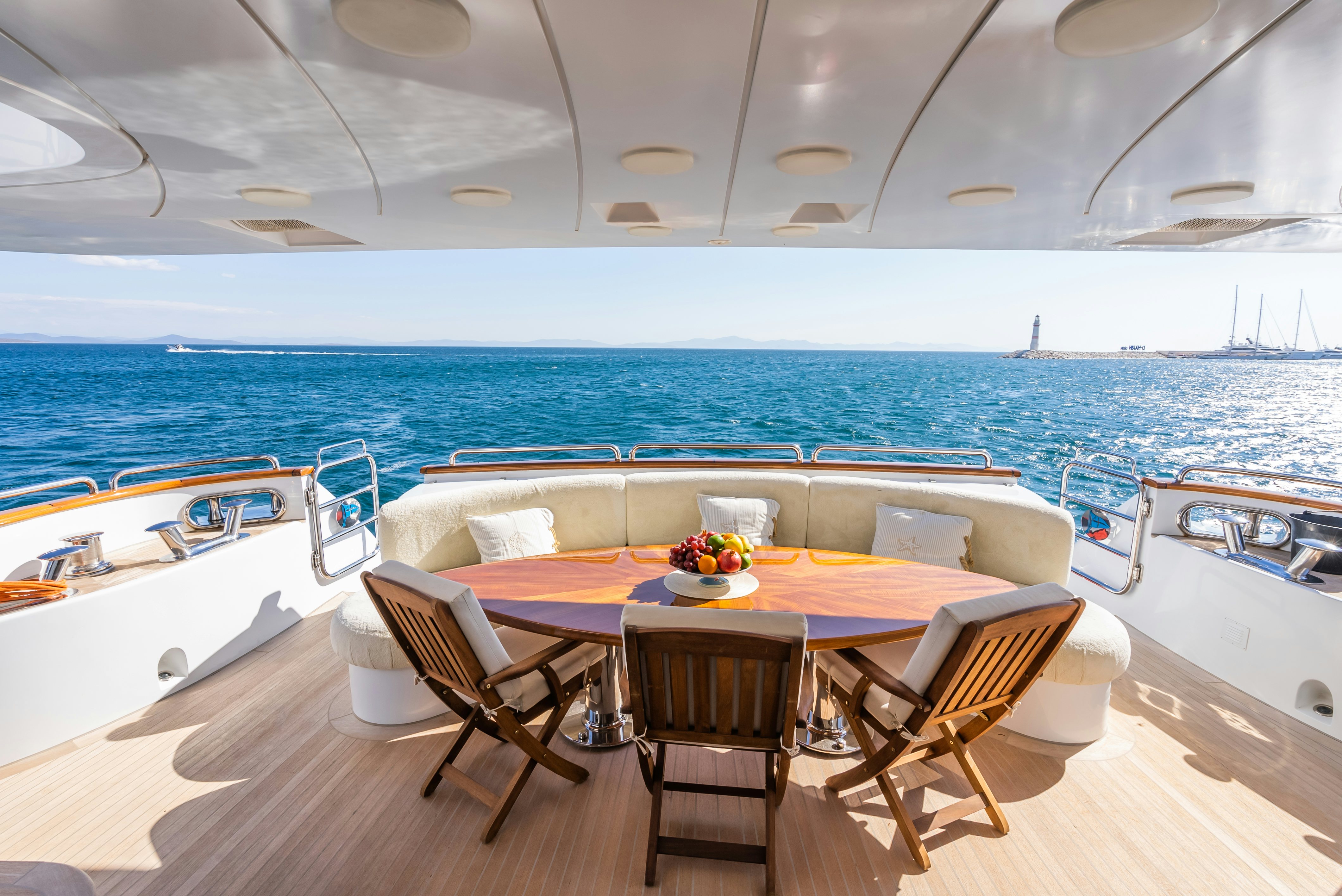 a table and chairs on a deck overlooking a large body of water aboard STELLA FIERA Yacht for Sale