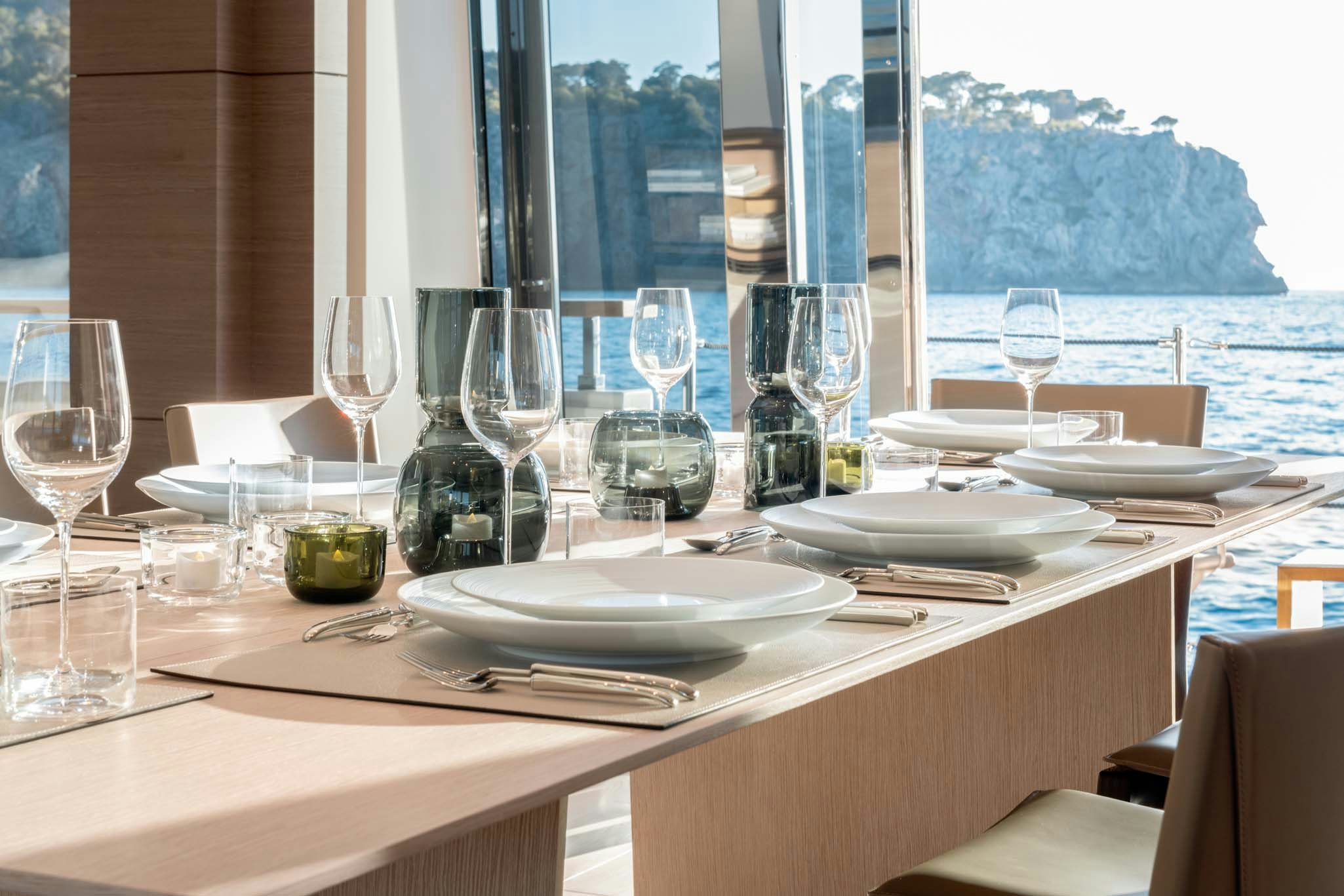 a table with wine glasses and plates aboard PALOMA Yacht for Charter