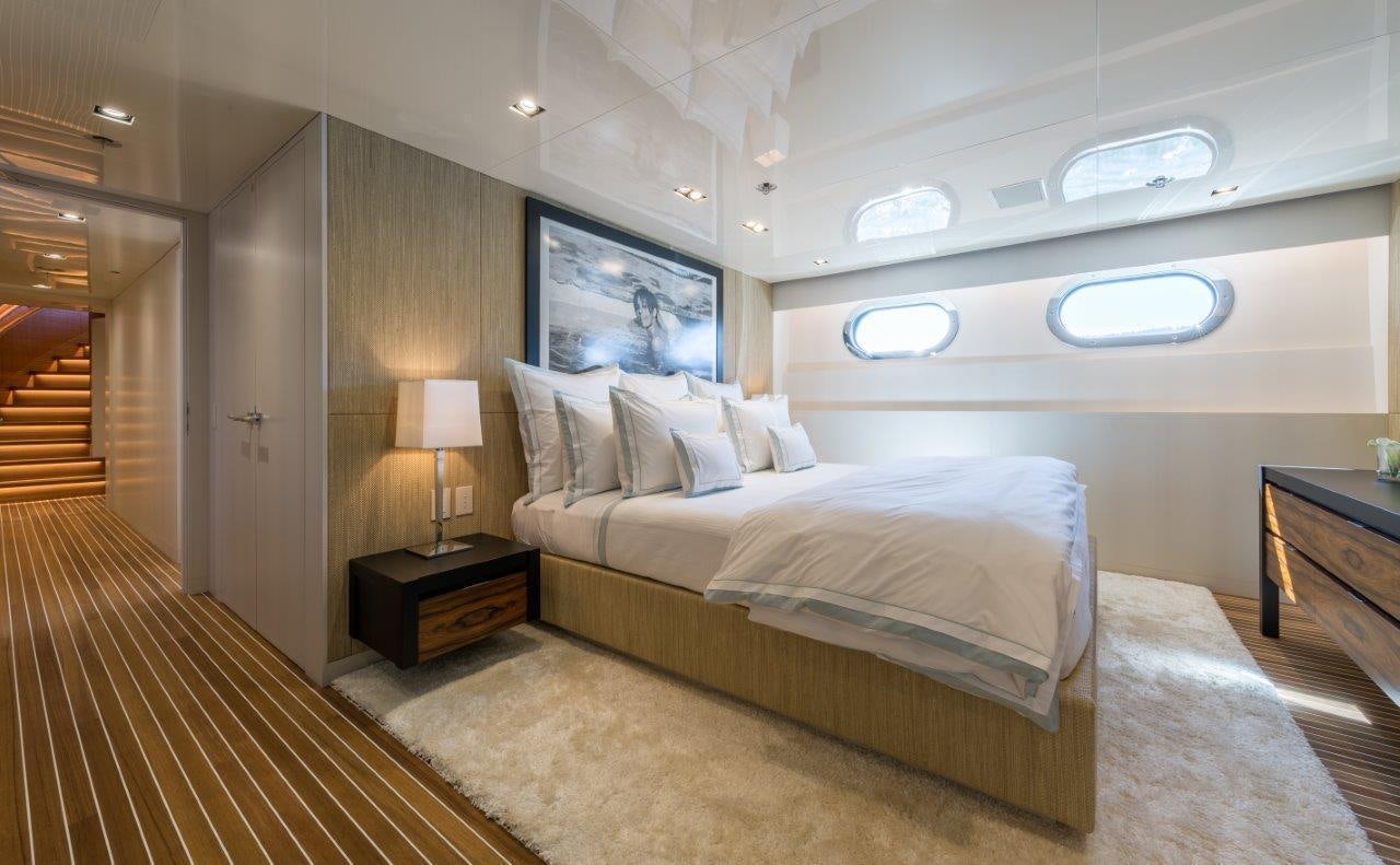 a bedroom with a bed and a lamp aboard CHASSEUR Yacht for Charter