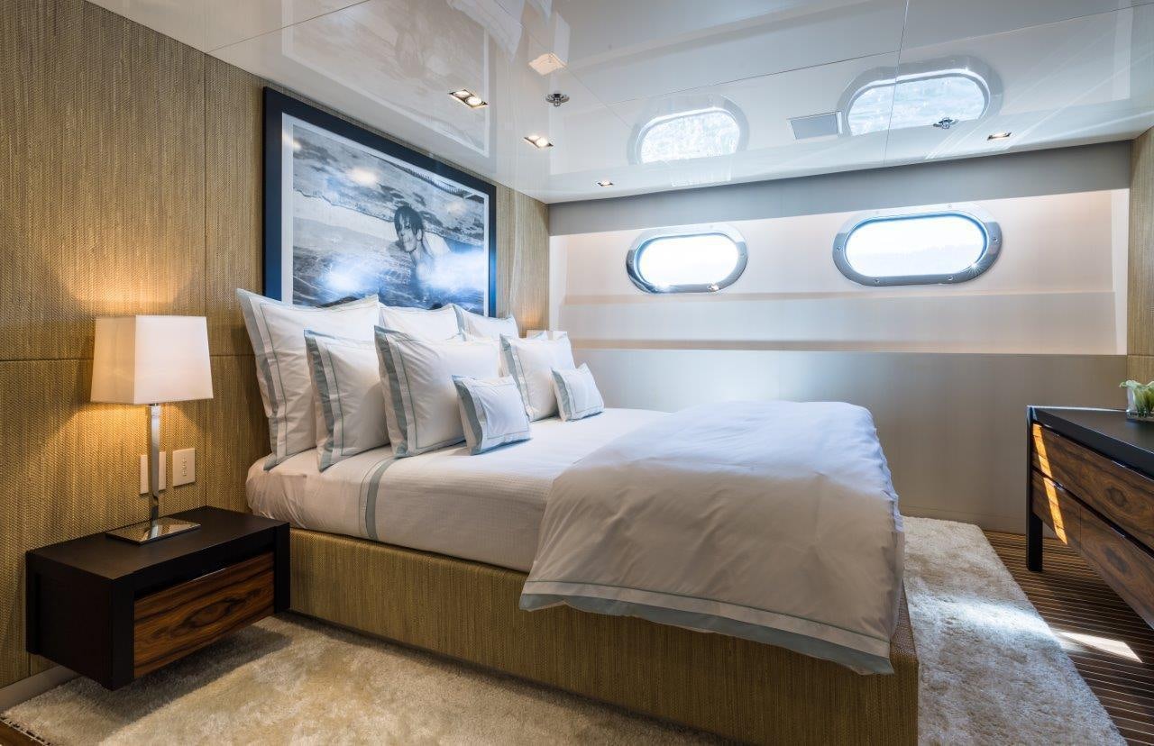a room with a bed and a lamp aboard CHASSEUR Yacht for Charter