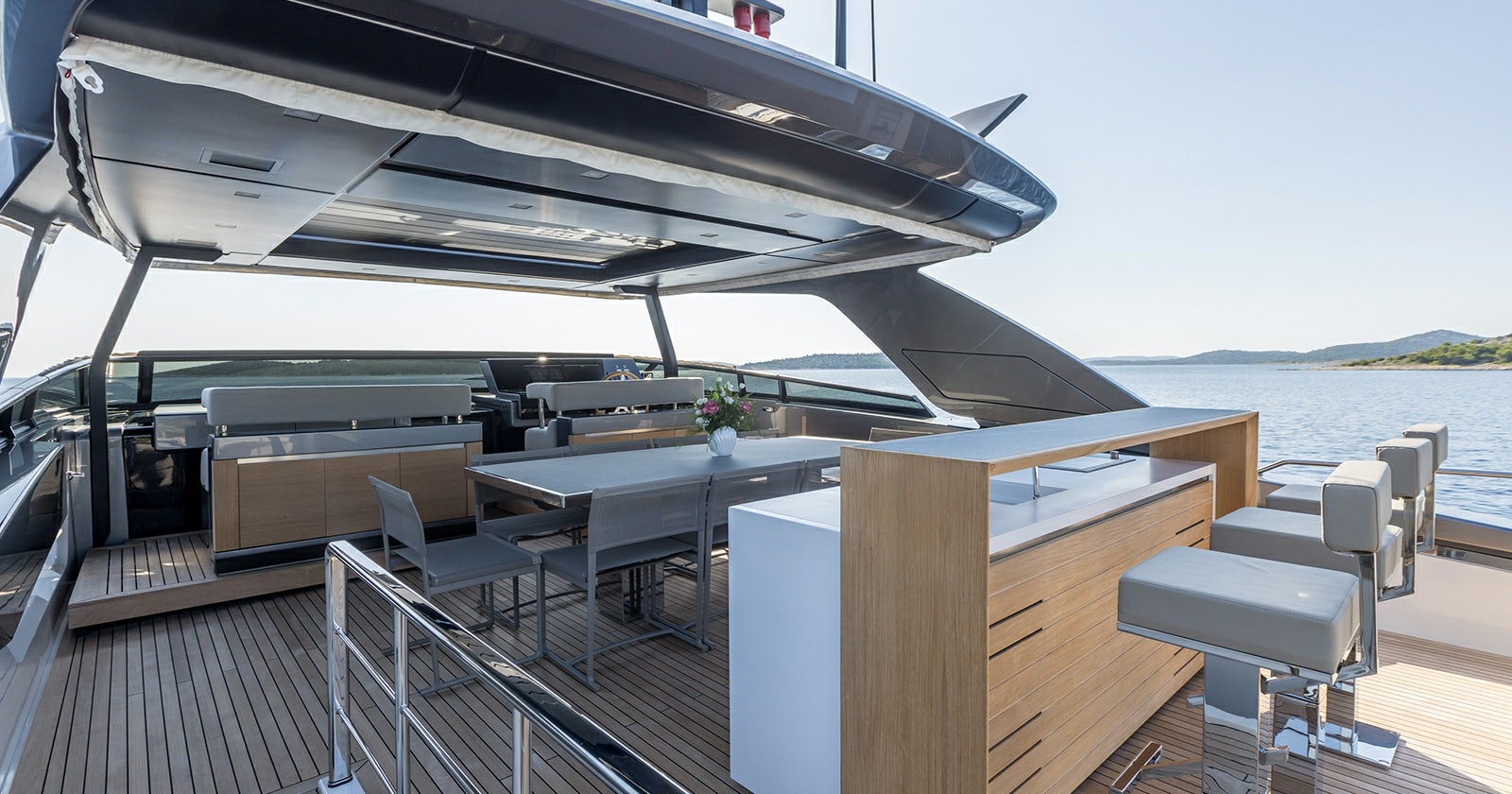 a deck with a table and chairs on it aboard JICJ Yacht for Sale