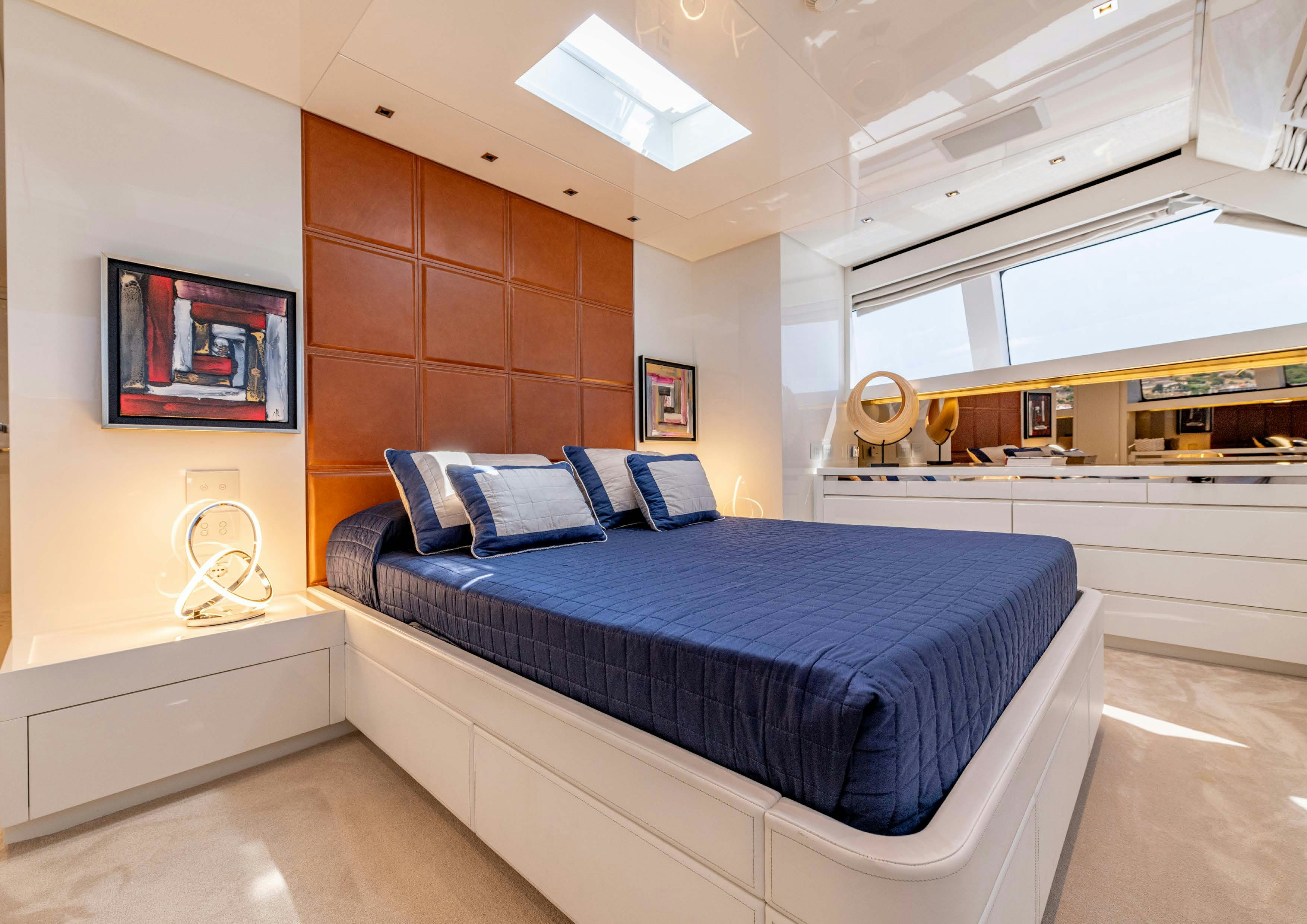 a bedroom with a bed and a large window aboard SERENITY IV Yacht for Sale