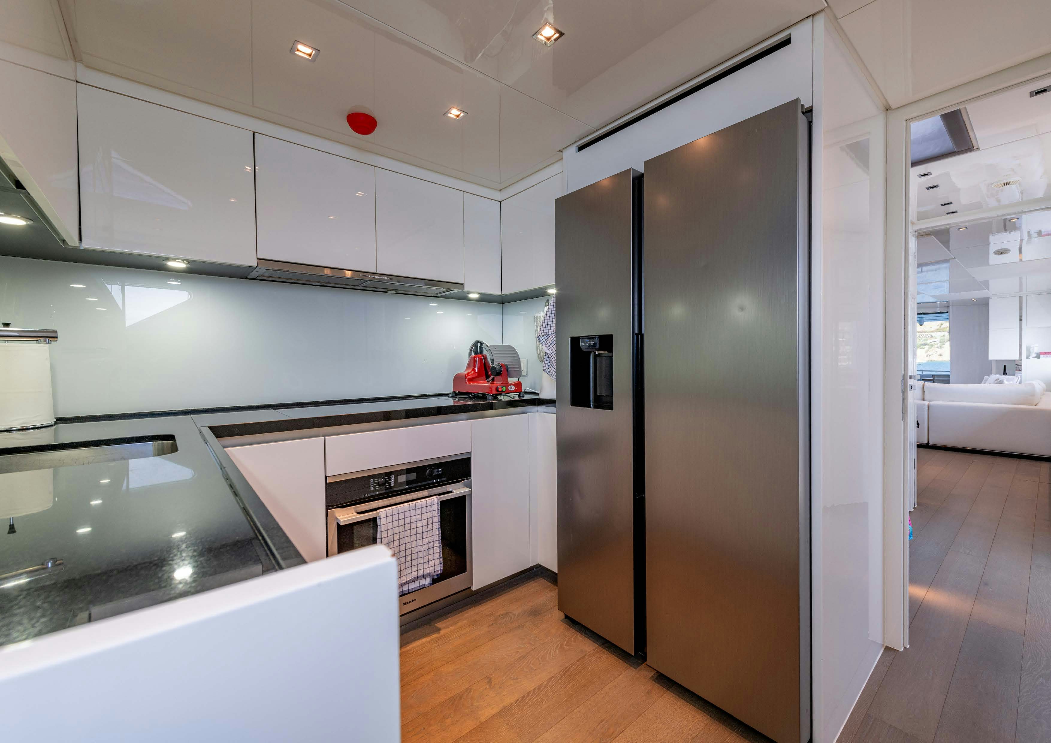 a kitchen with white cabinets aboard SERENITY IV Yacht for Sale