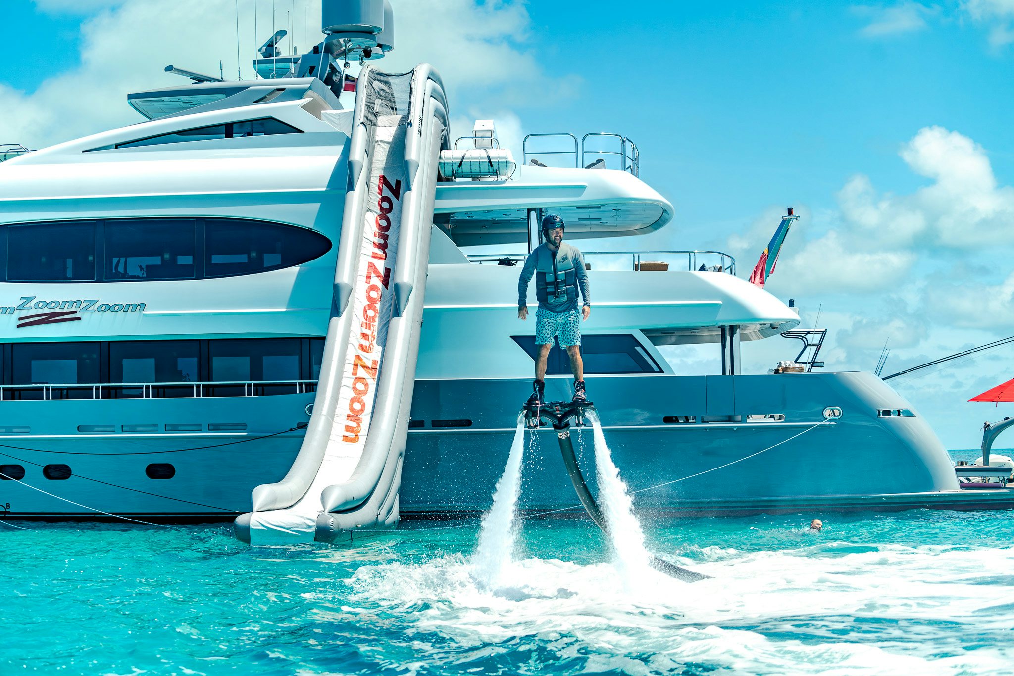 a person standing on a ladder on a plane in the water aboard ZOOM ZOOM ZOOM Yacht for Charter