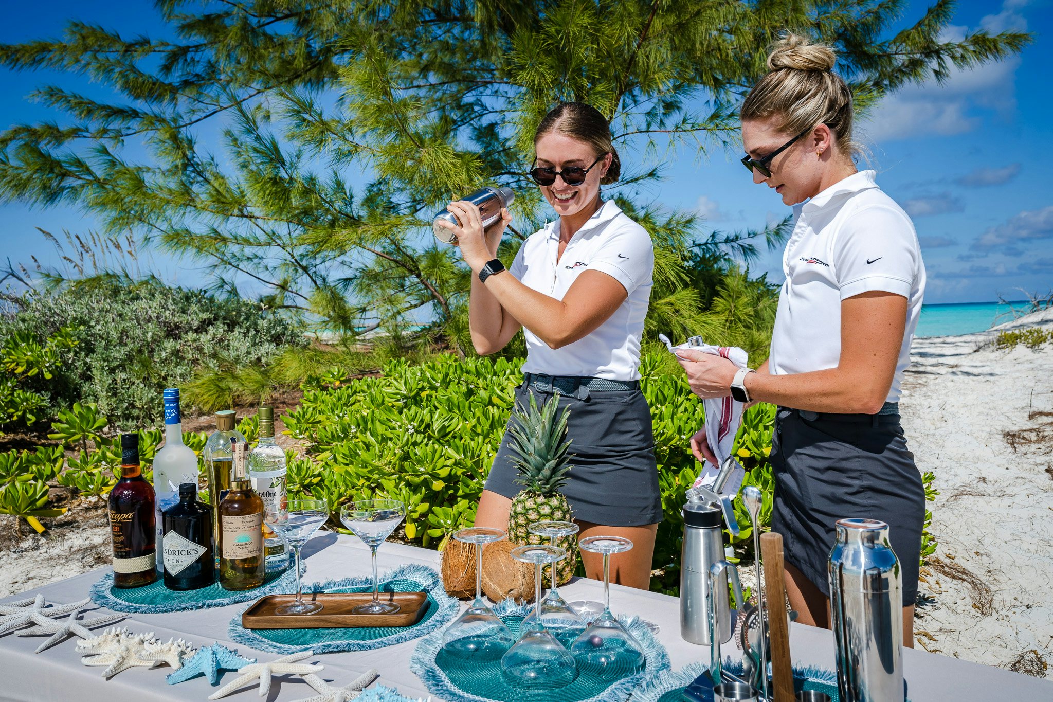 a couple of men standing by a table with food and drinks on it aboard ZOOM ZOOM ZOOM Yacht for Charter