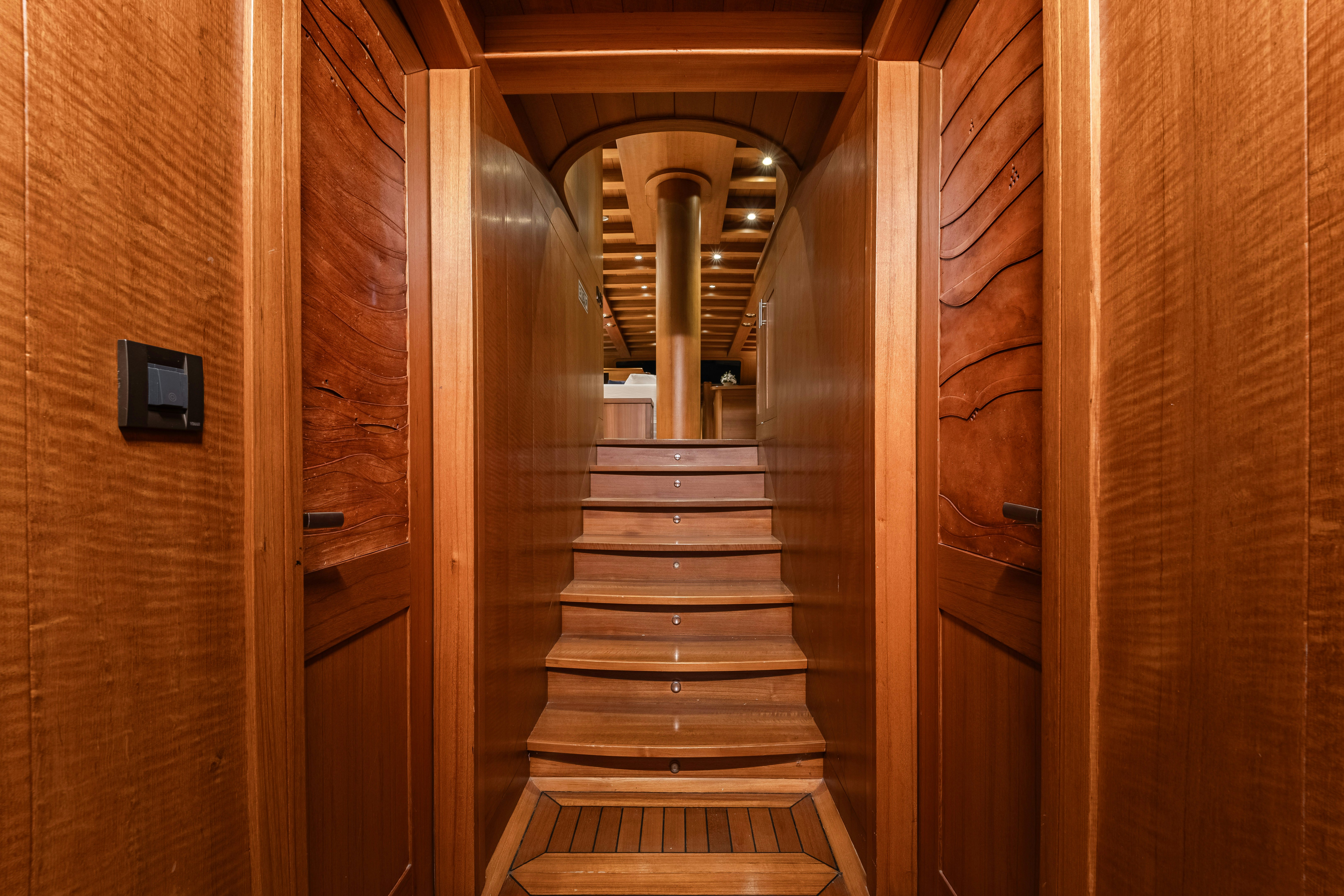 a wooden staircase with a wood railing aboard CAKIRYILDIZ Yacht for Sale