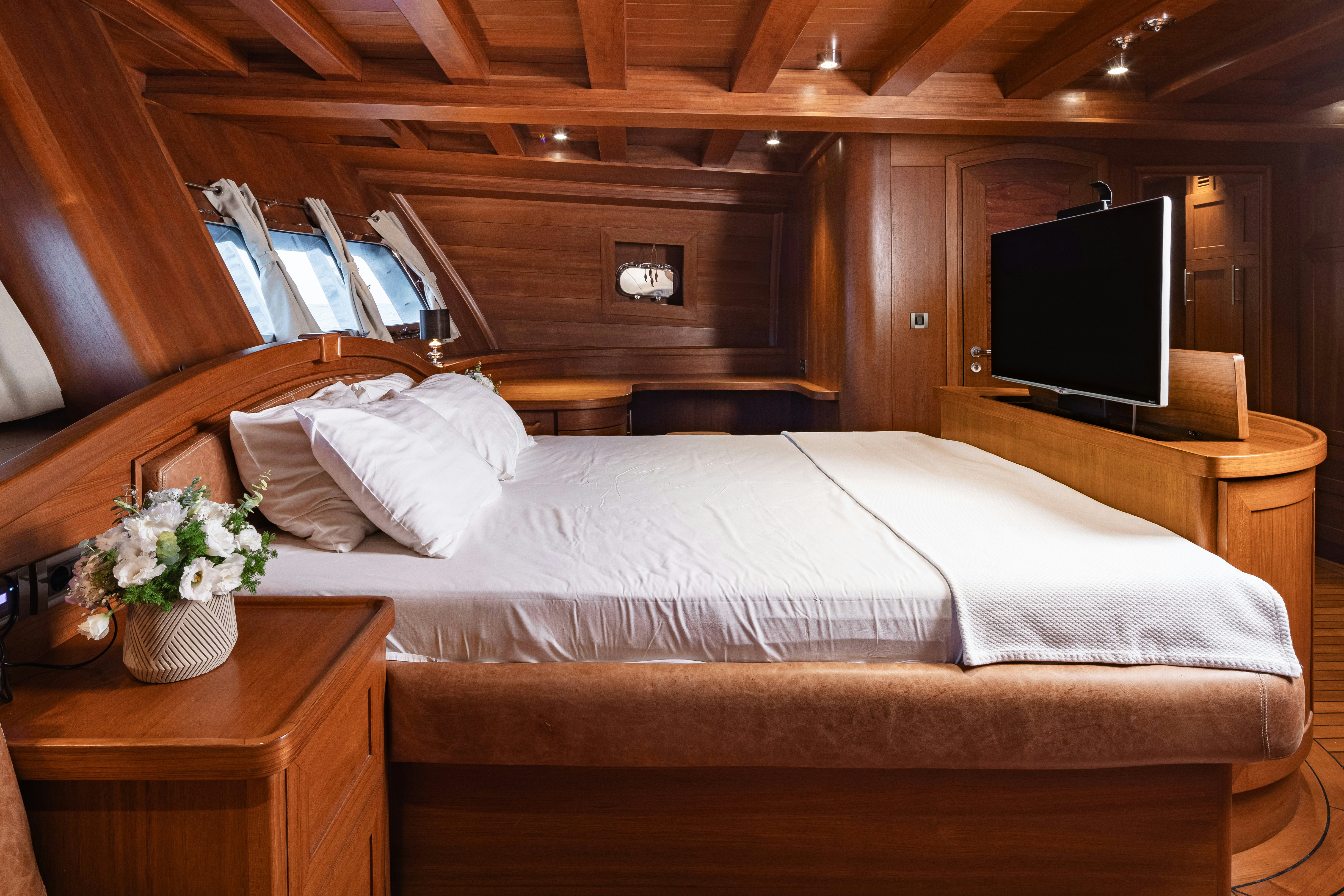 a bed with a television on the wall aboard CAKIRYILDIZ Yacht for Sale