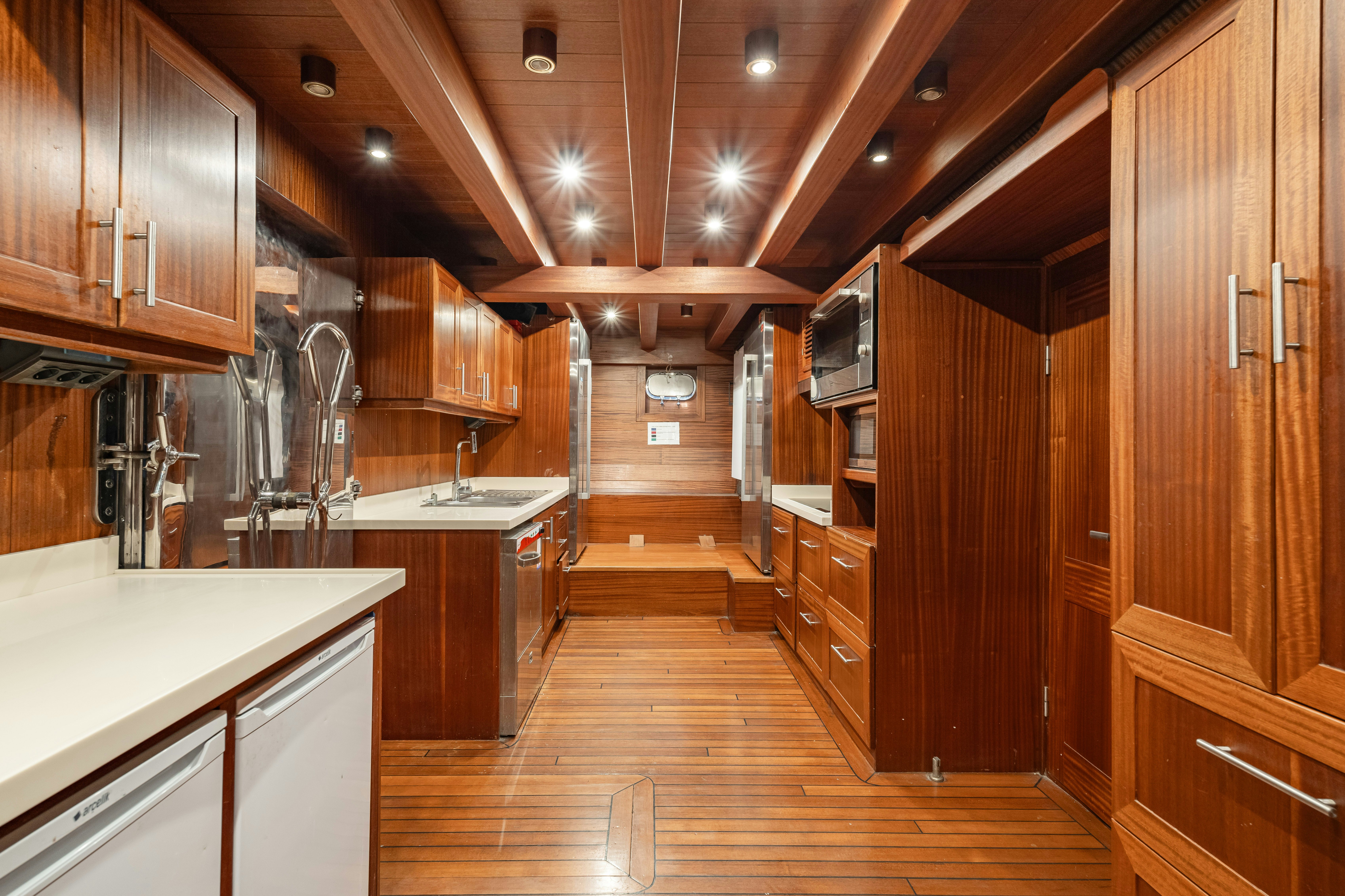 a large kitchen with wooden cabinets aboard CAKIRYILDIZ Yacht for Sale